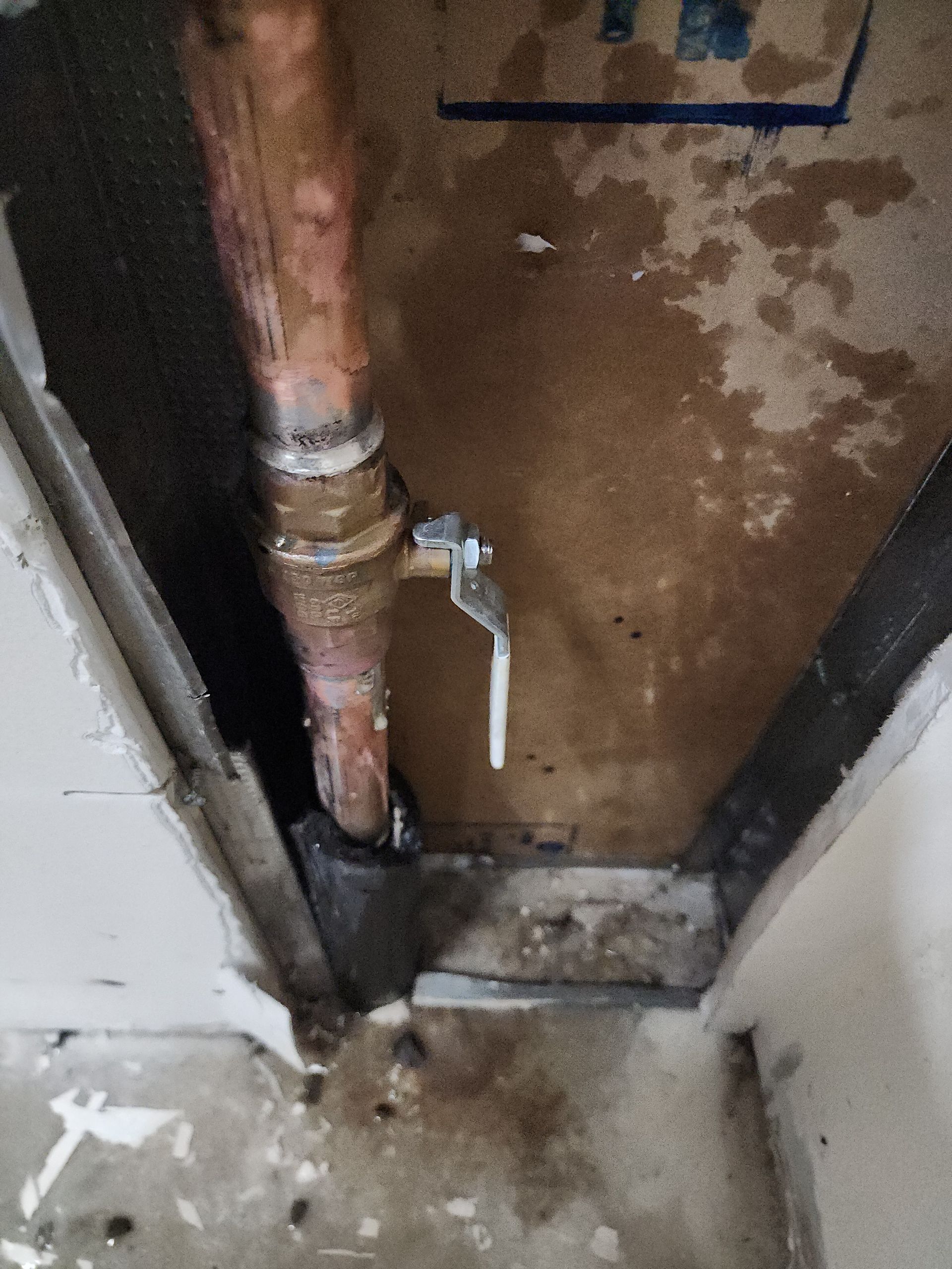 Plumber using a wrench to connect a water supply line to a faucet near a bathroom sink.