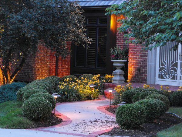 A brick house with a walkway leading to the front door