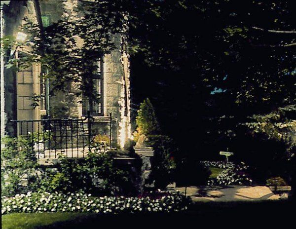 A house with a fence and flowers in front of it