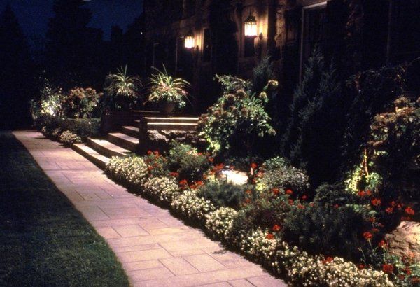 A walkway is lit up at night in front of a house