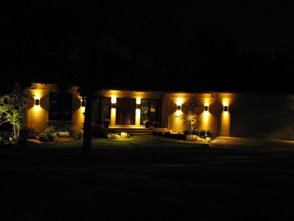 The front of a house is lit up at night.