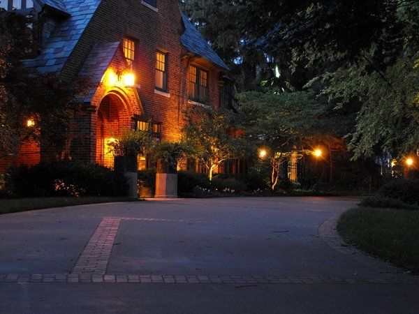 A large brick house is lit up at night