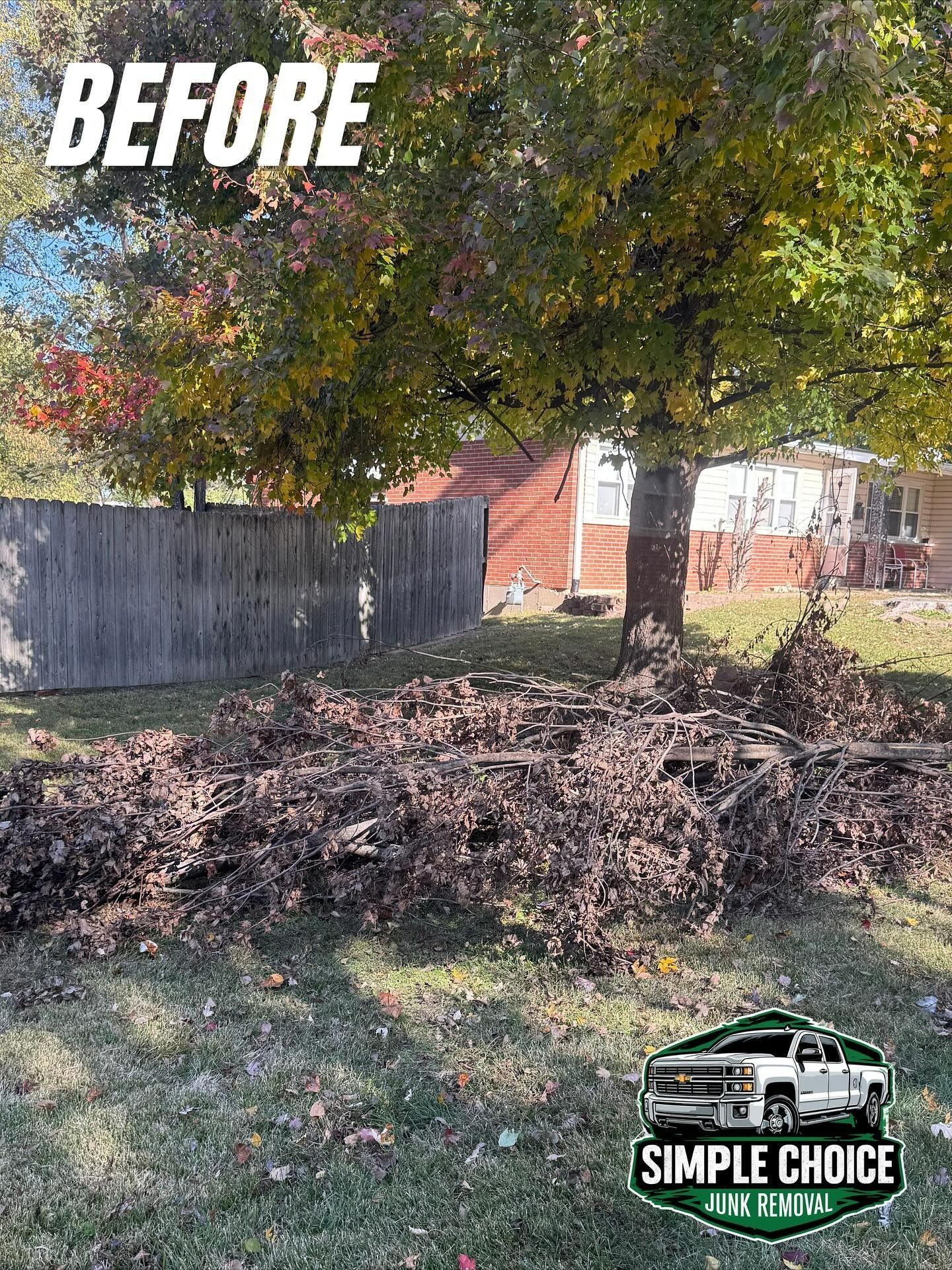 A yard cluttered with debris and a tree before cleanup, with a house and fence in the background.