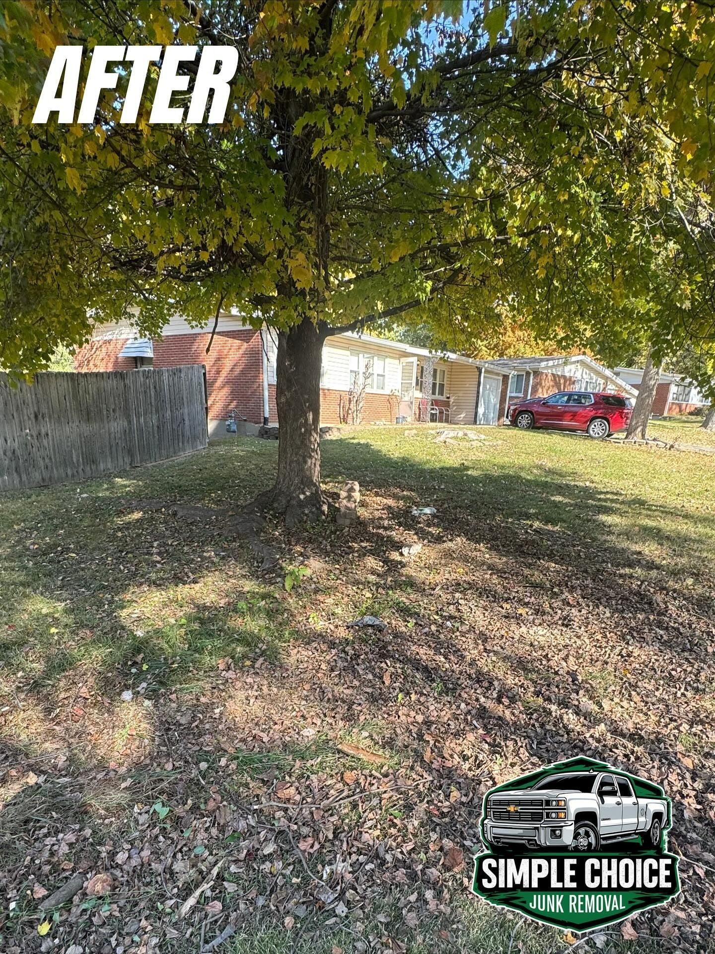 After: Lawn under a tree with a house and red truck in the background. 