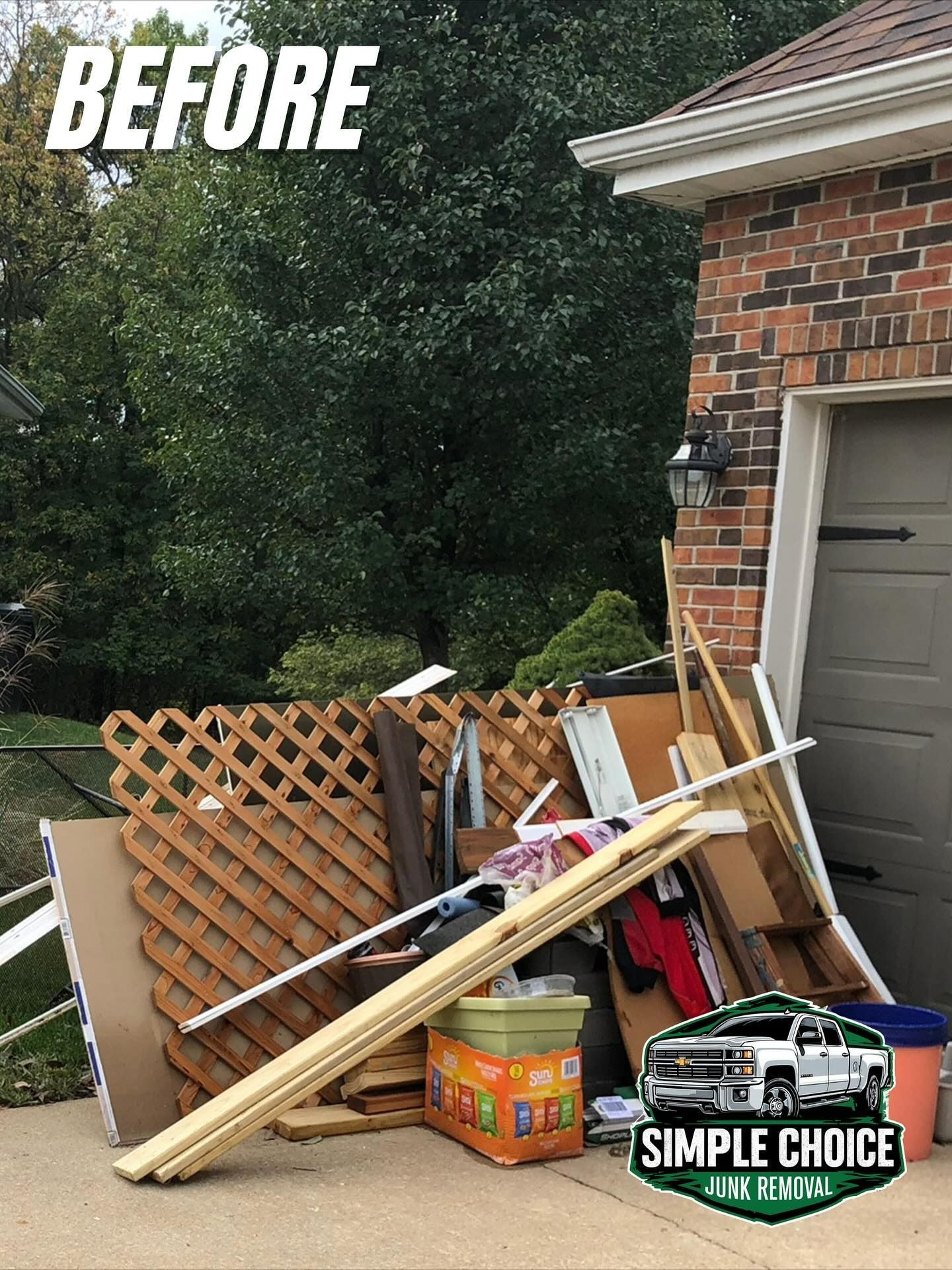 Pile of debris, including wood and cardboard, in front of a garage, with the word 