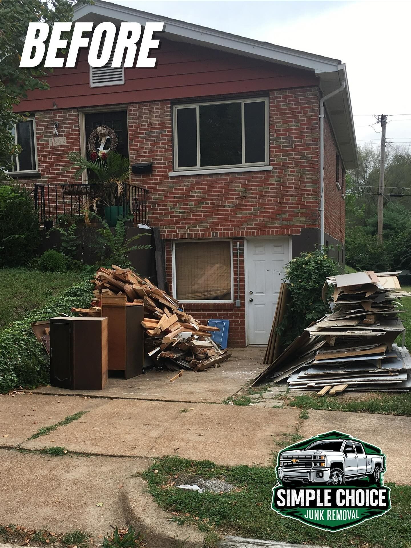 House exterior before cleanup with debris on driveway. Red brick, two stories. 