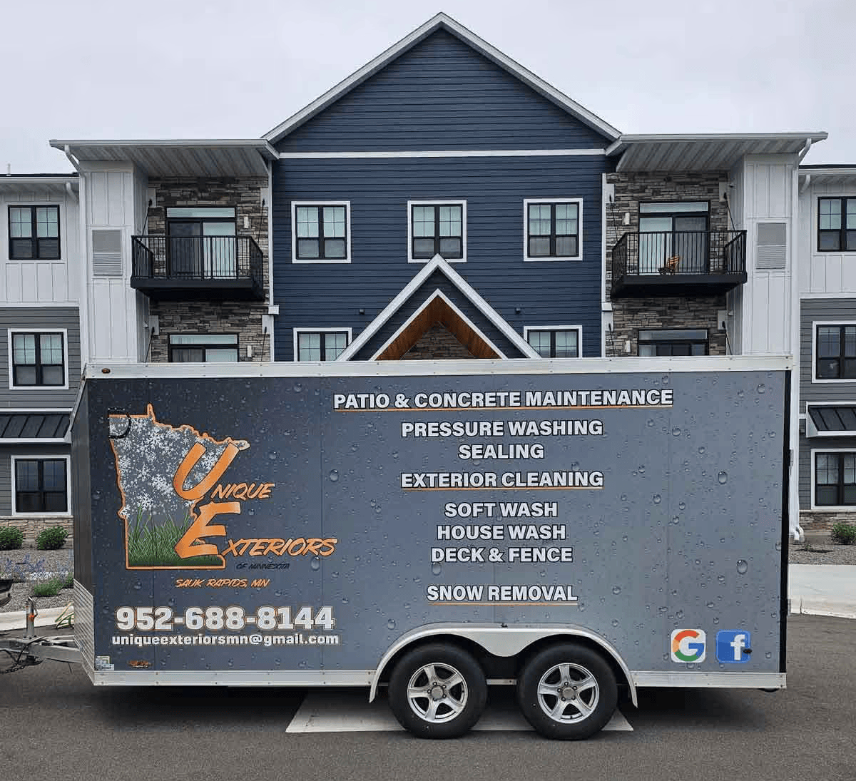 A trailer is parked in front of a large building.