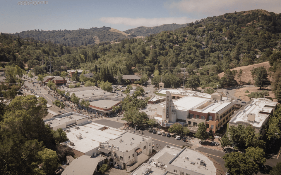 An aerial view of a small town surrounded by trees and mountains.