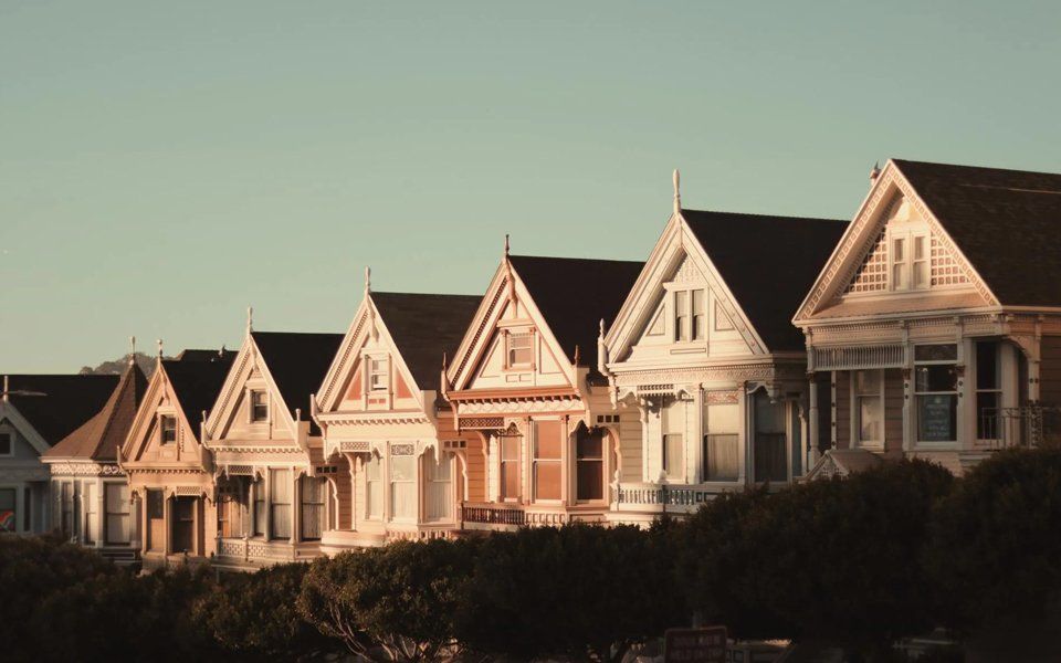 A row of houses with a blue sky in the background