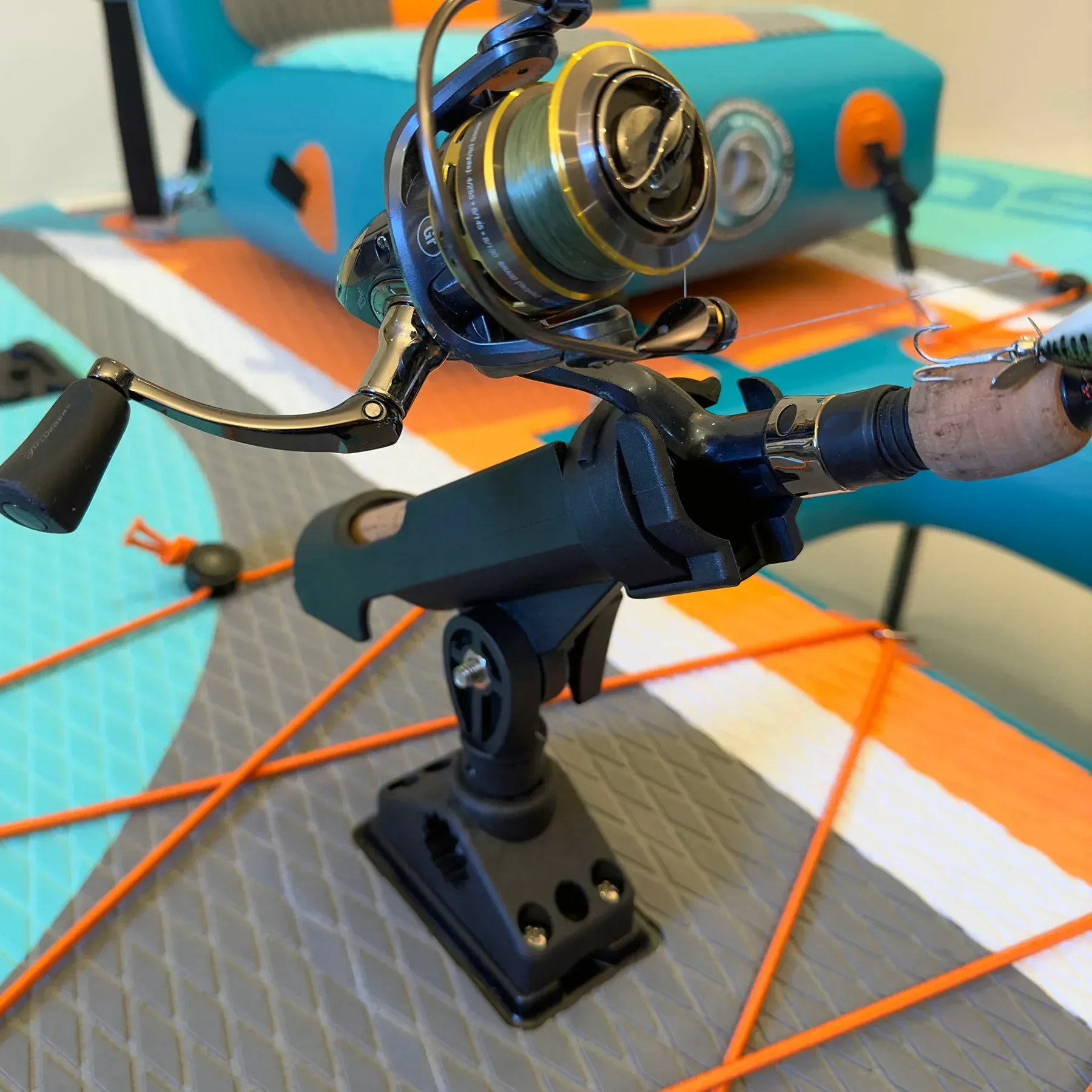 A fishing rod and reel are sitting on a paddle board