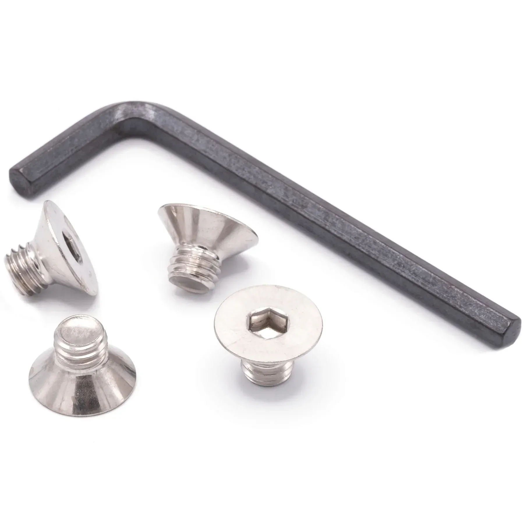 A set of screws and a wrench on a white surface