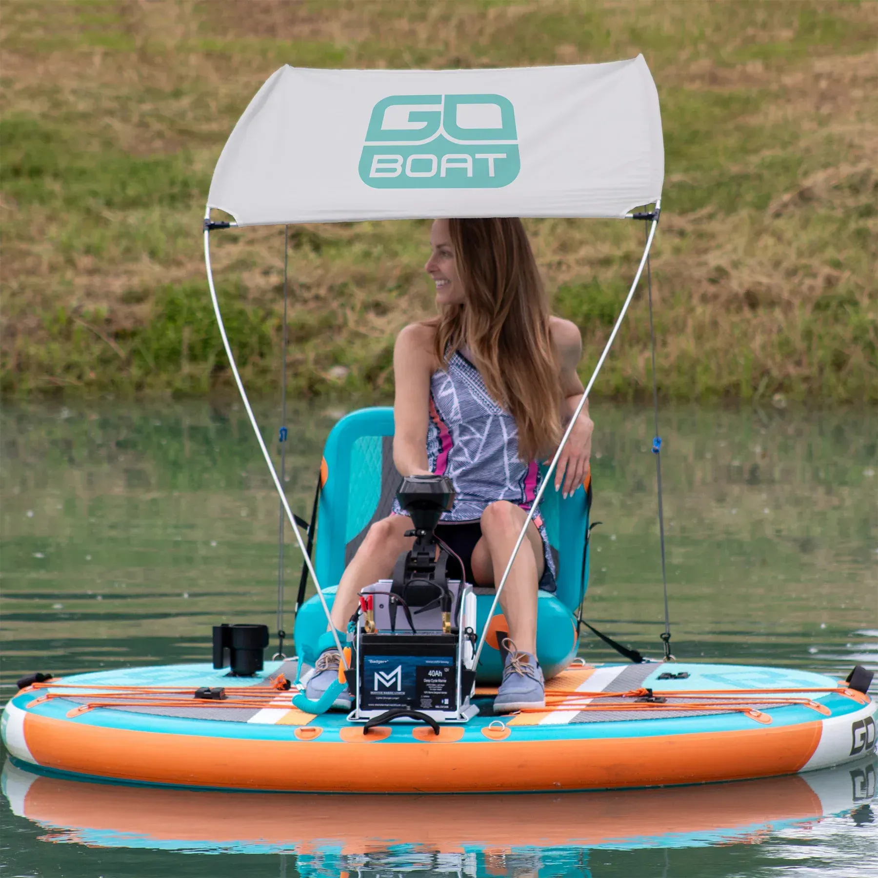 A woman is sitting on a go boat in the water.