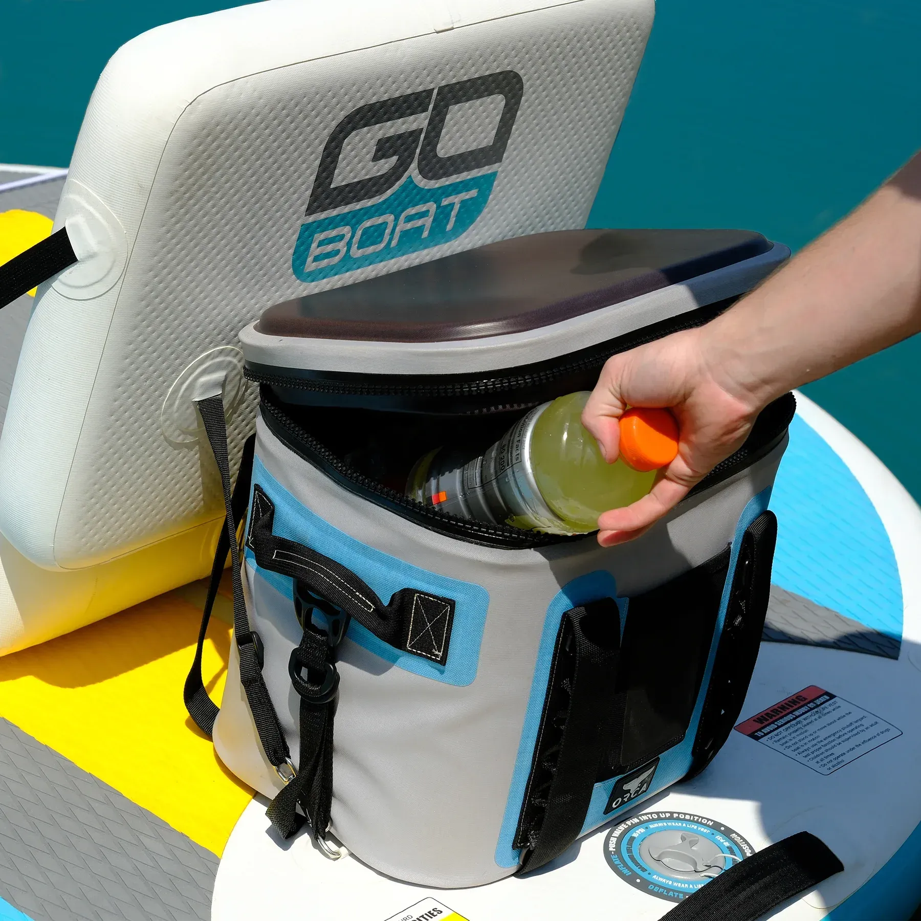 A person is holding a bottle in a go boat cooler