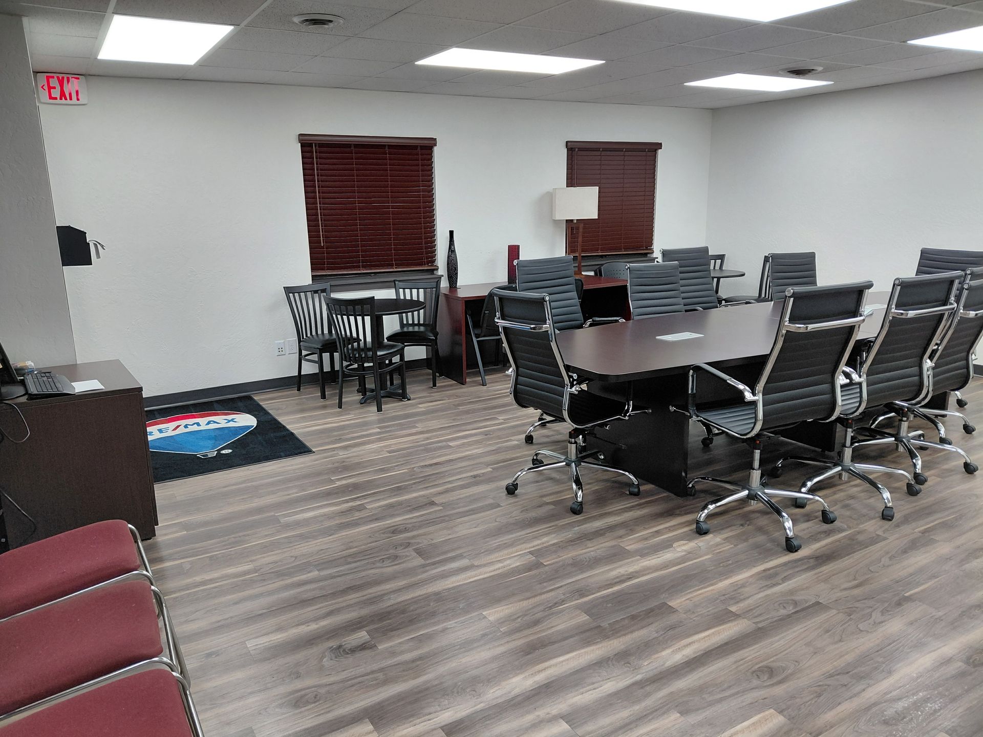A person mops wet stairs, wearing an apron and gloves, with a cleaning cart and caution sign nearby.