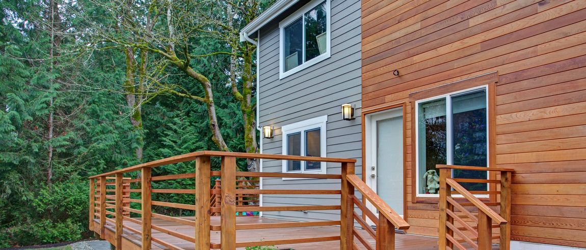 A house with a wooden deck in front of it.