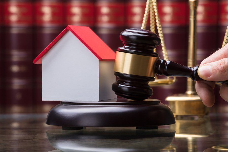 Concept of bankruptcy with a gavel, scale and house