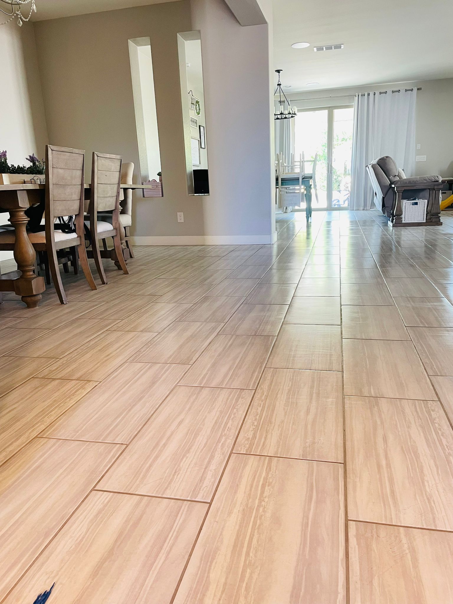 A living room with a wooden floor and a table and chairs.