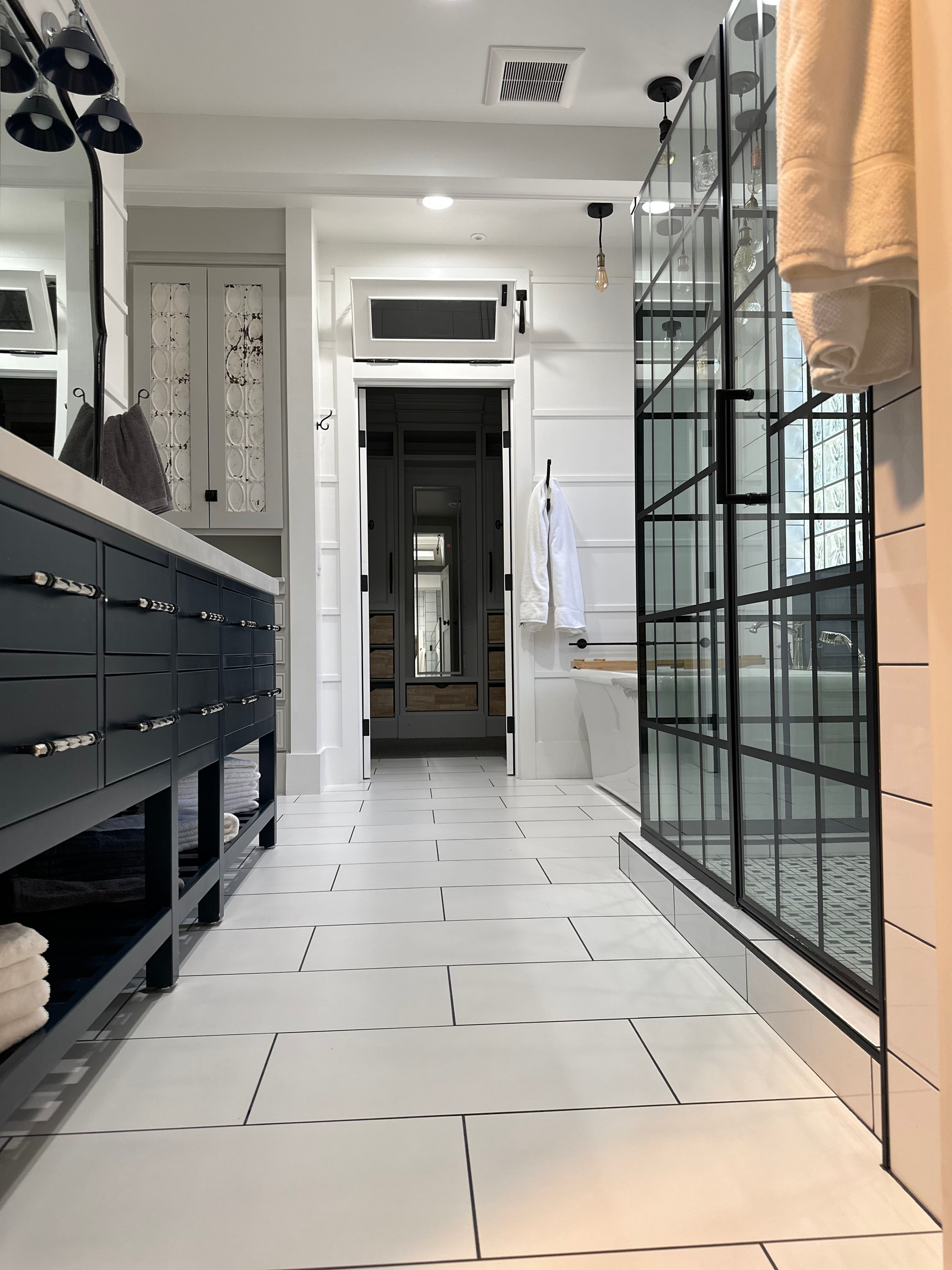 A bathroom with a walk in shower and two sinks