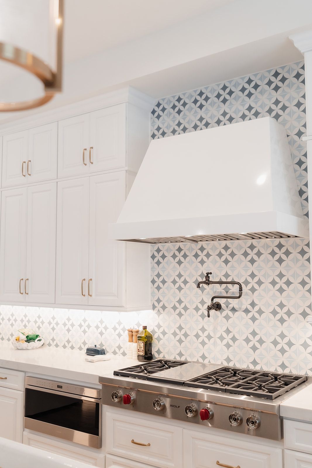 A kitchen with white cabinets and a stove top oven