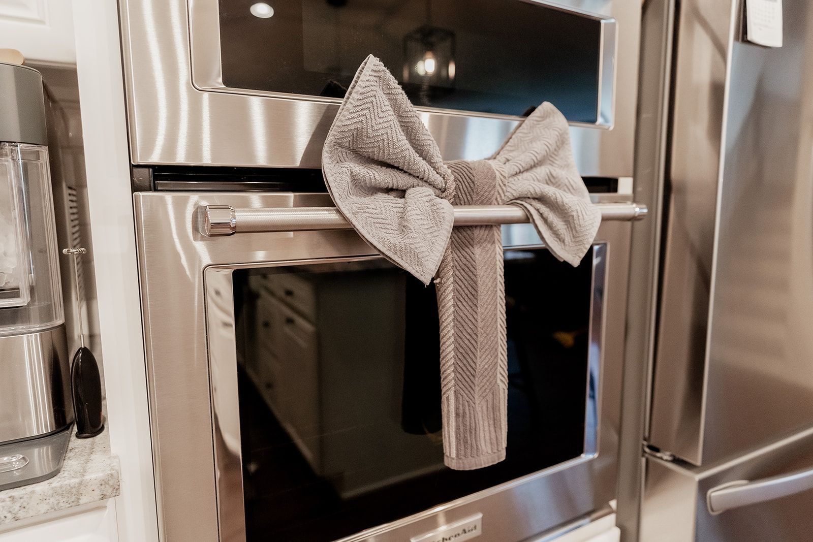 A stainless steel oven with a bow on it in a kitchen.