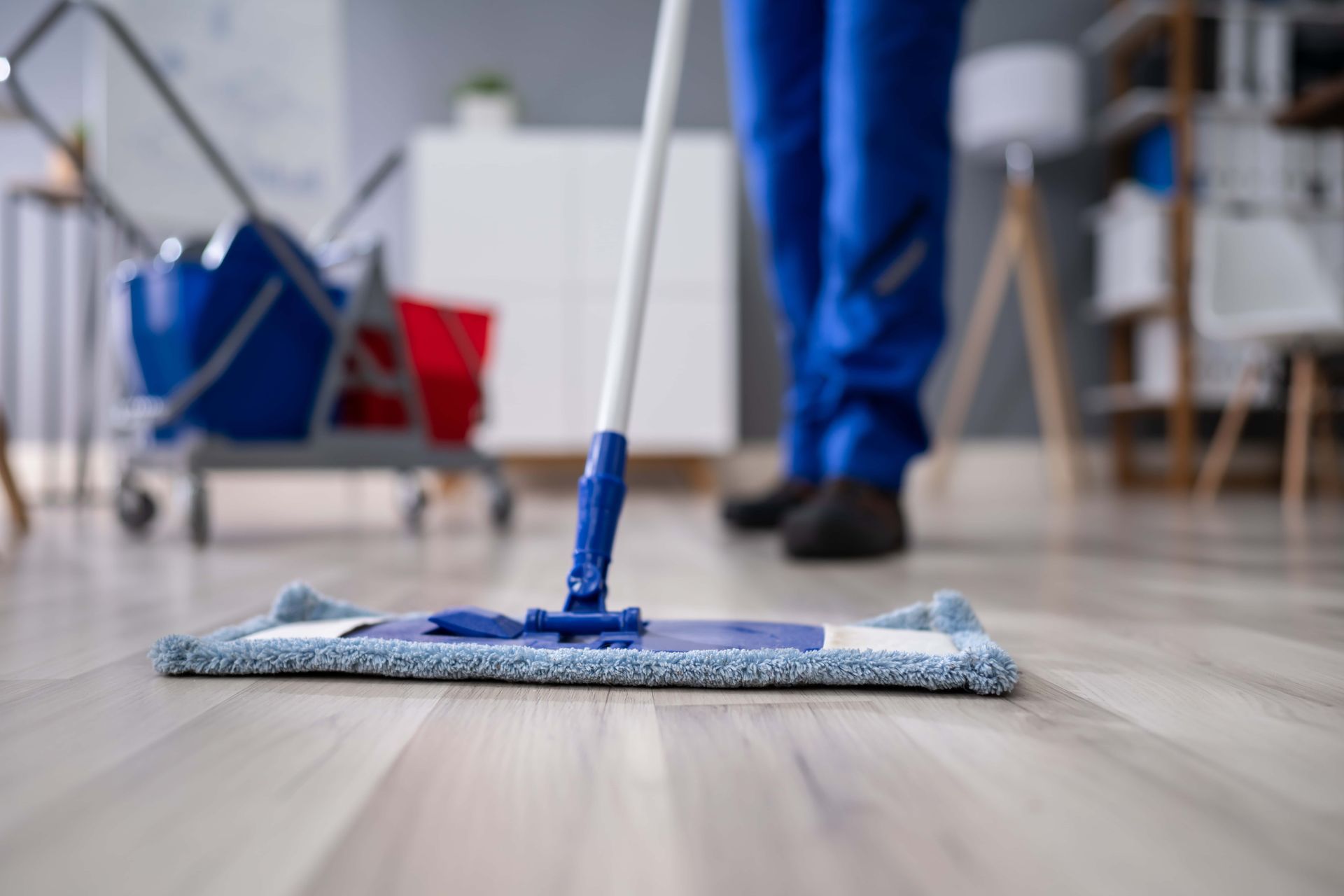 A person is cleaning the floor with a mop.