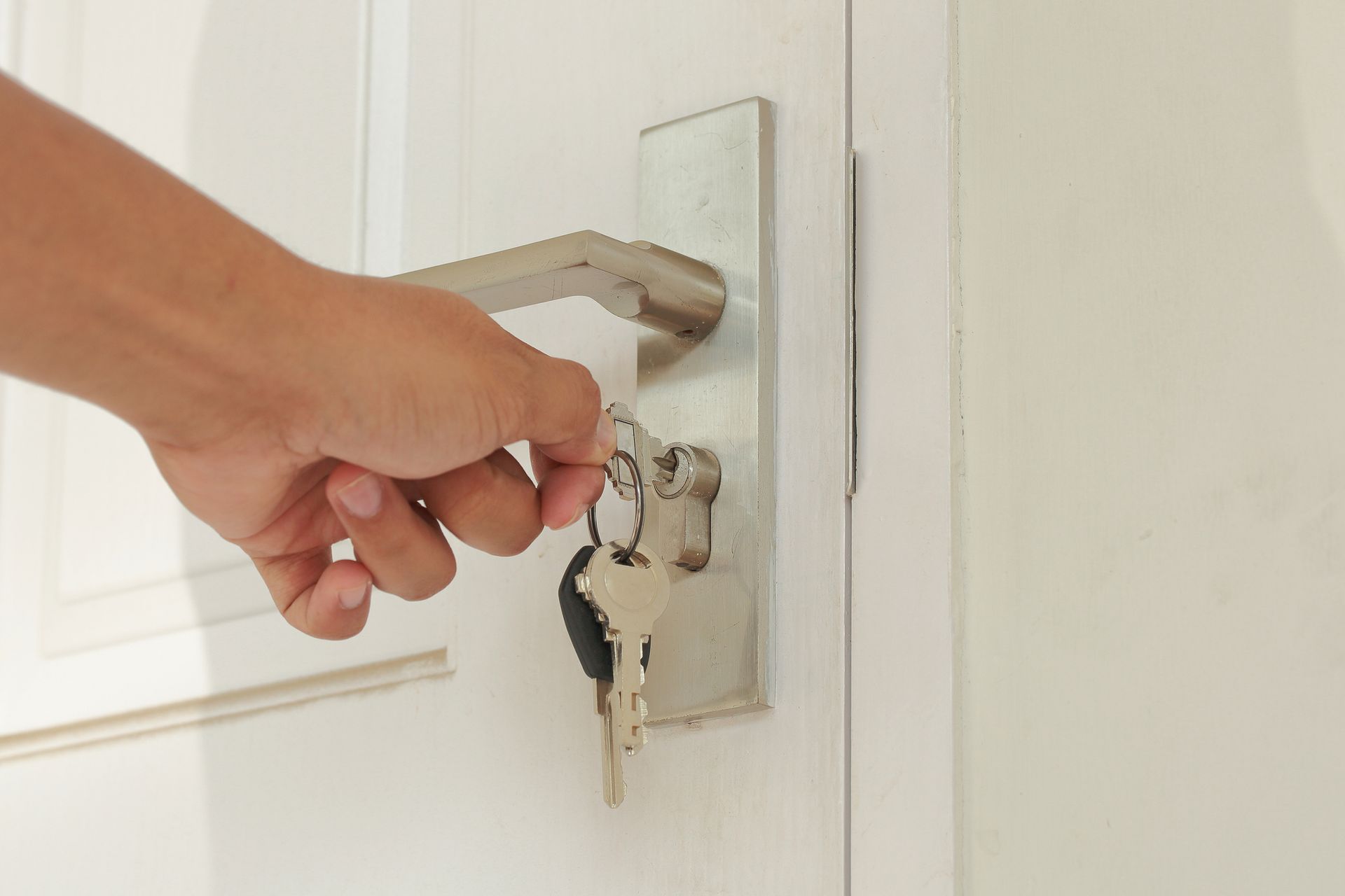 A person is opening a door with a key.