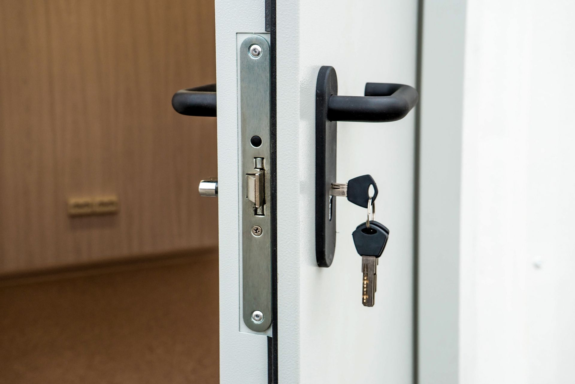 A close up of a door with two keys in it.
