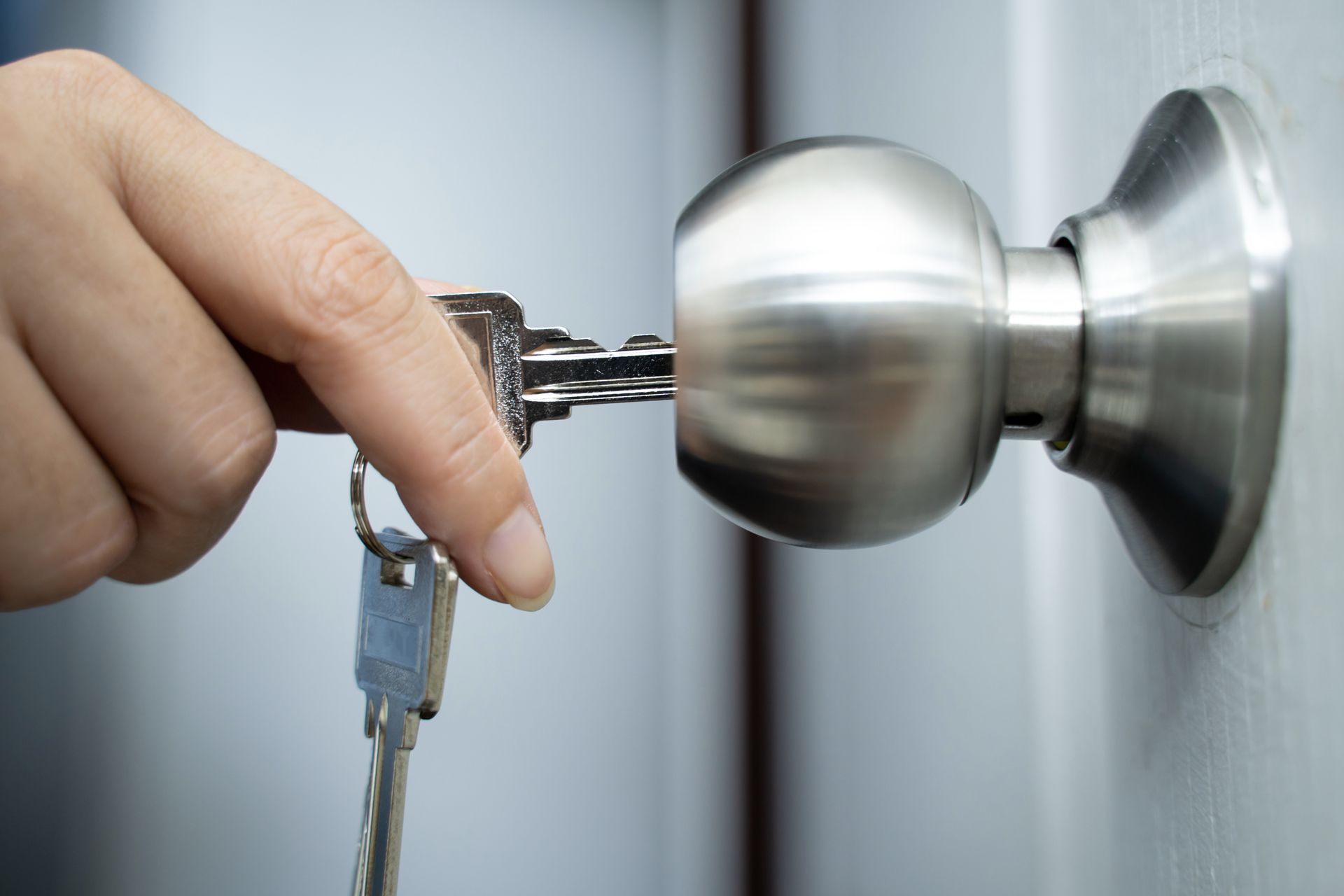 A person is opening a door with a key.