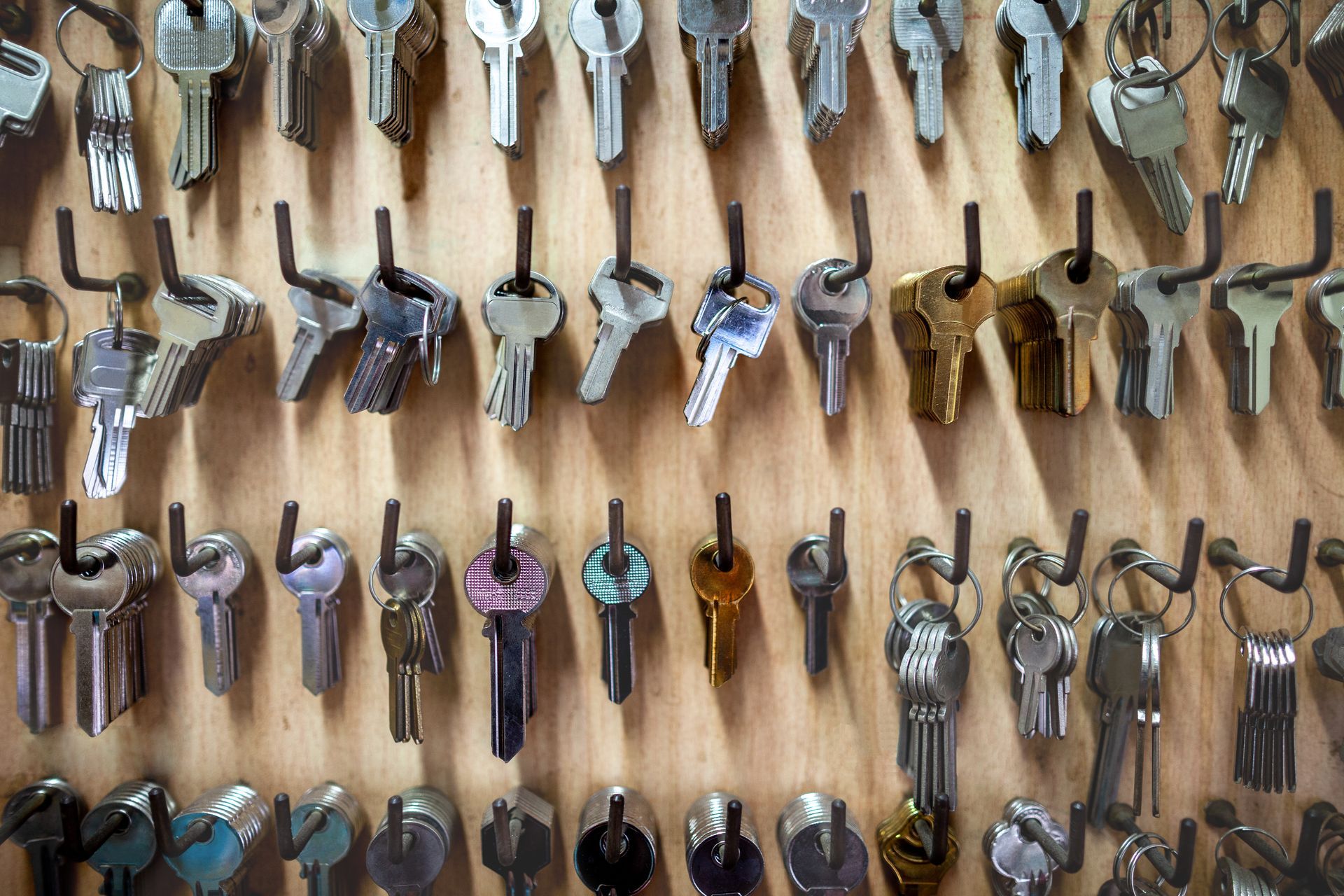 A bunch of keys are hanging on a wall.