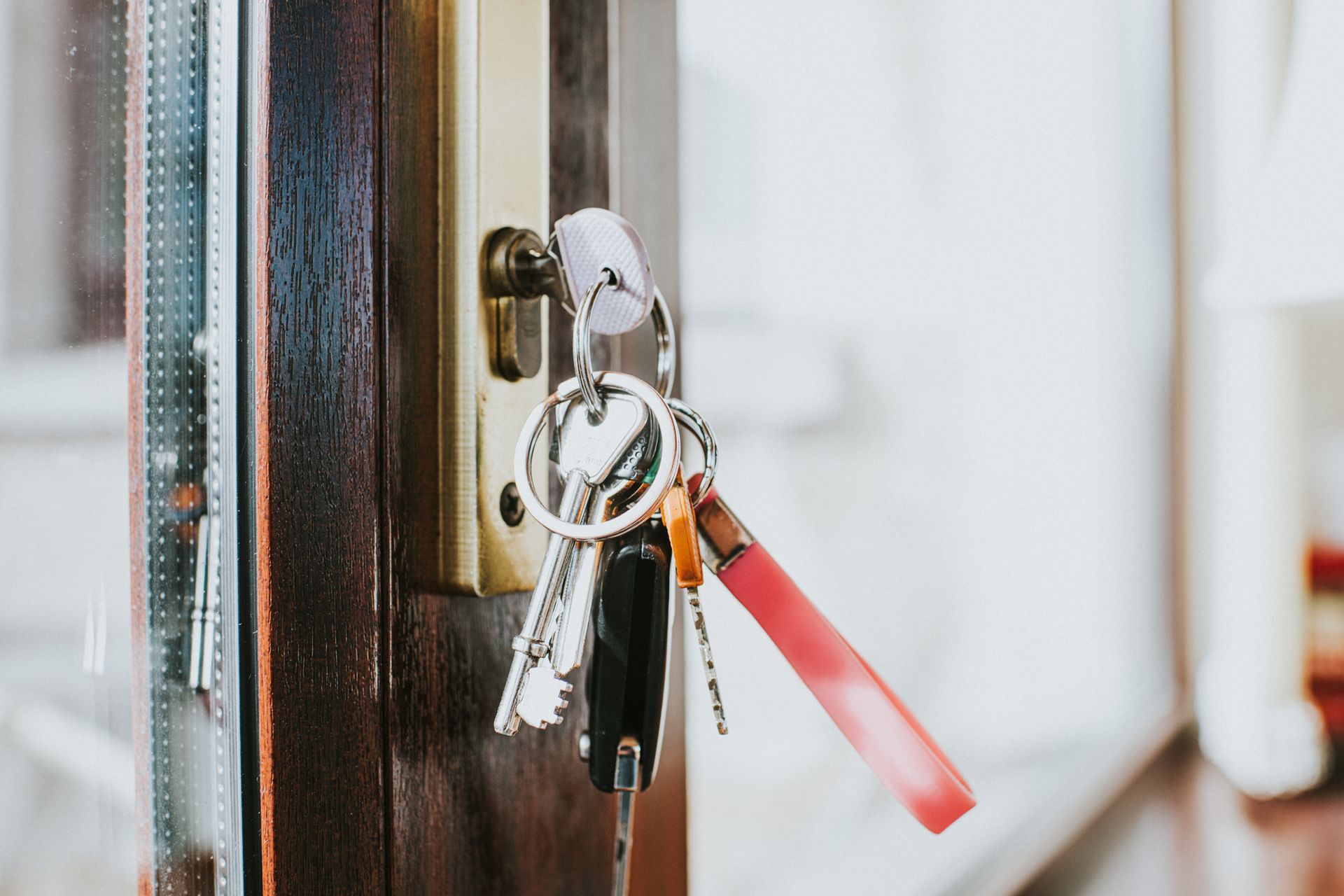 A bunch of keys are hanging from a door lock.