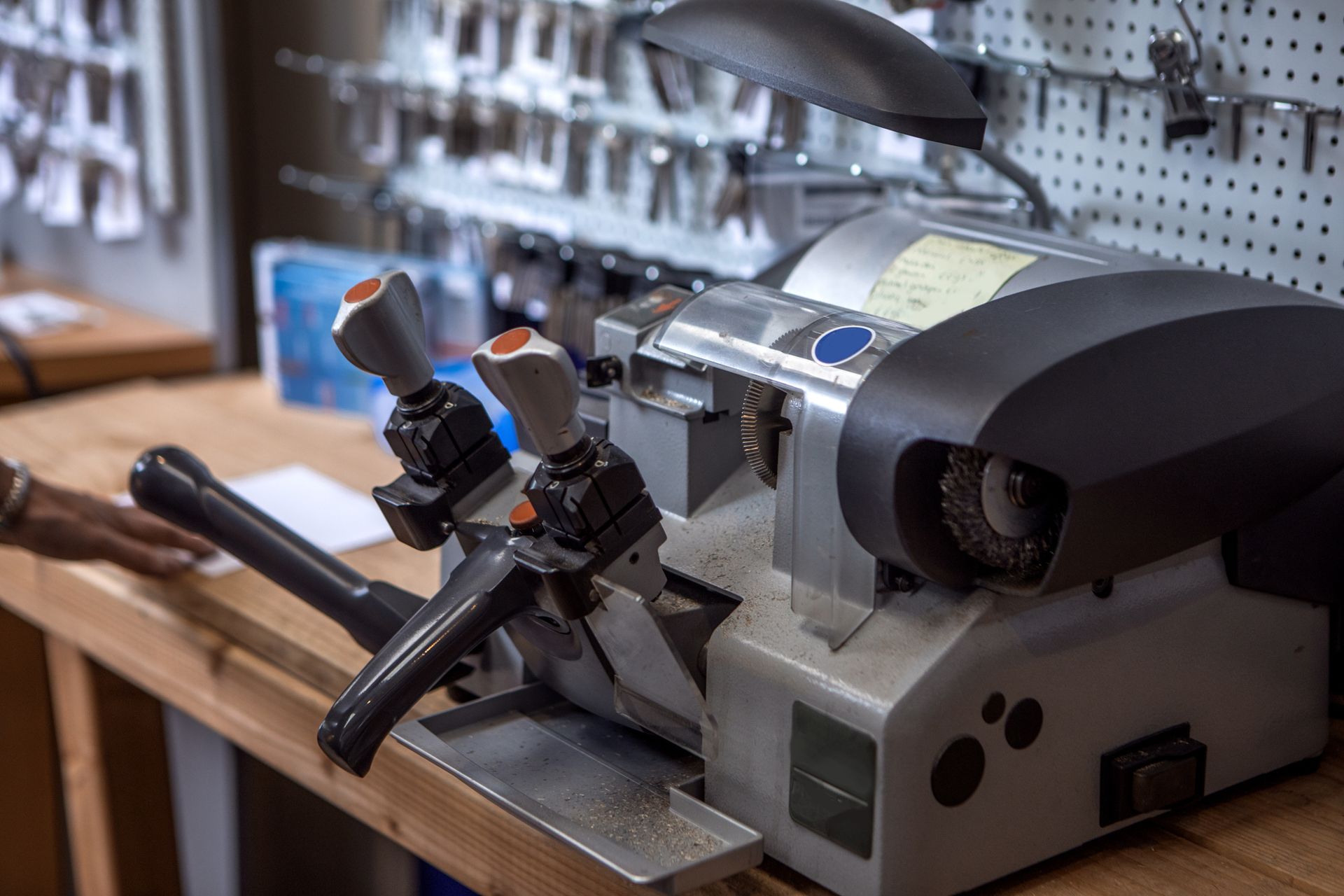 A key cutting machine is sitting on a wooden table.