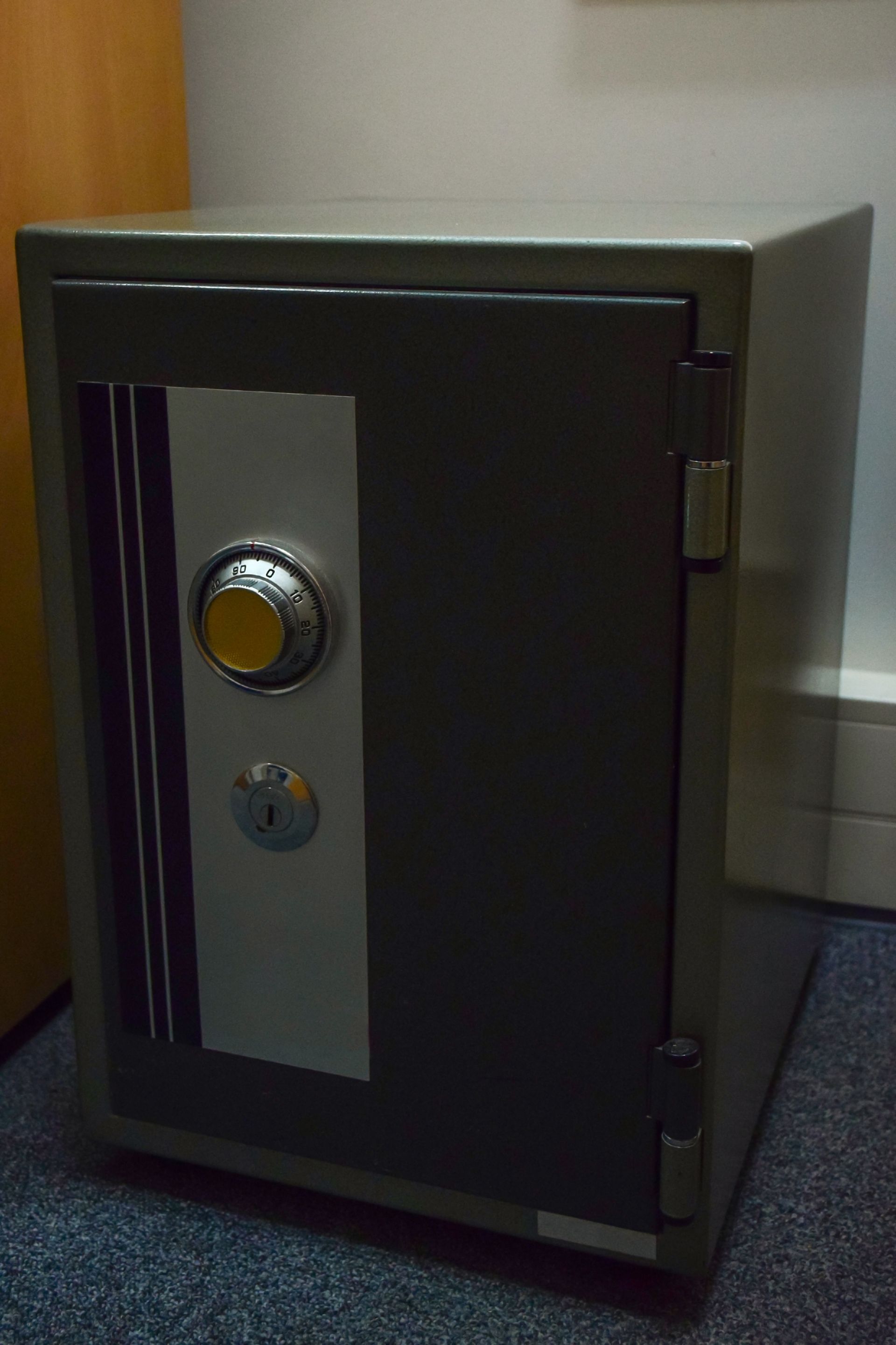 A safe is sitting on the floor in a room.