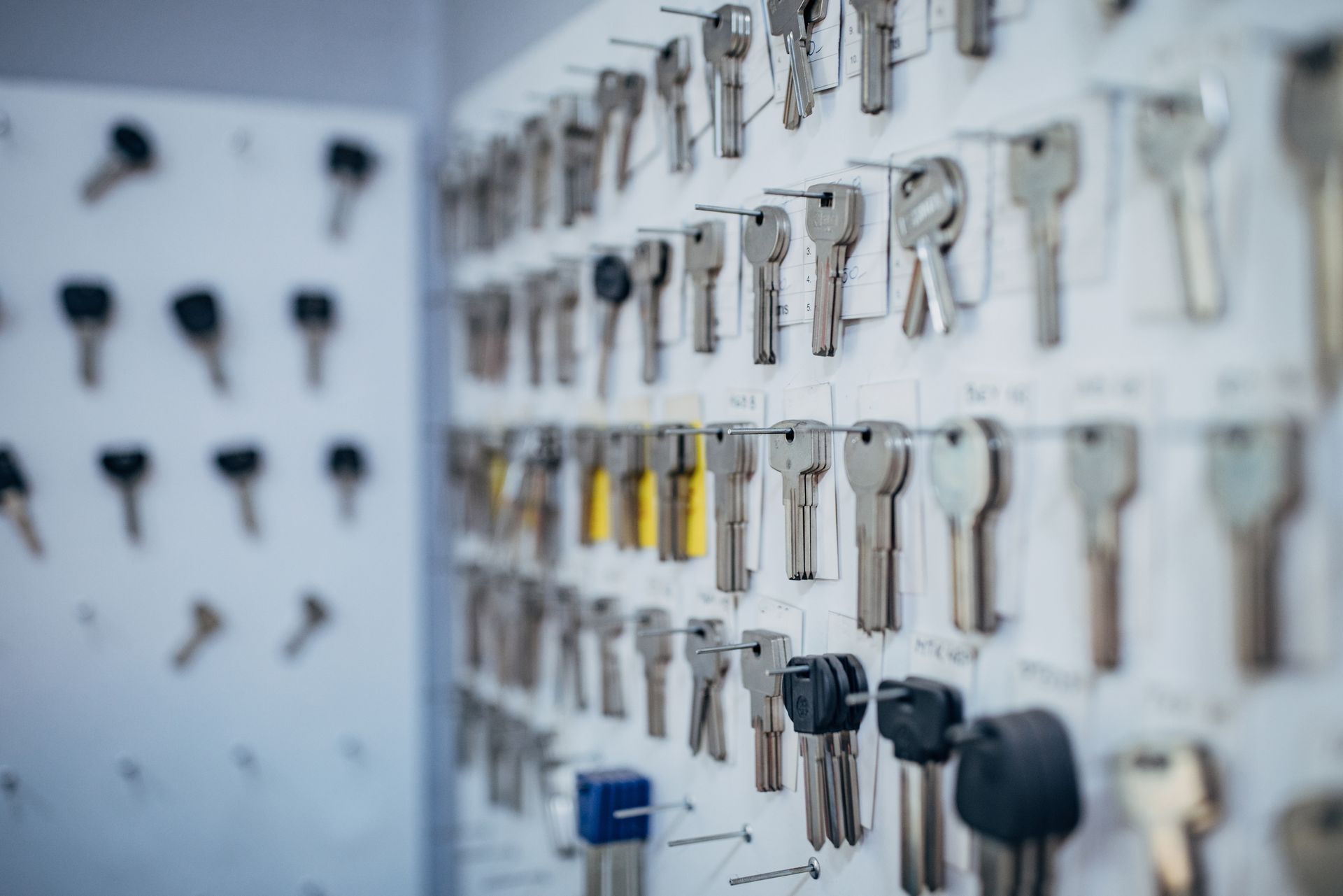 A bunch of keys are hanging on a wall in a locksmith shop.