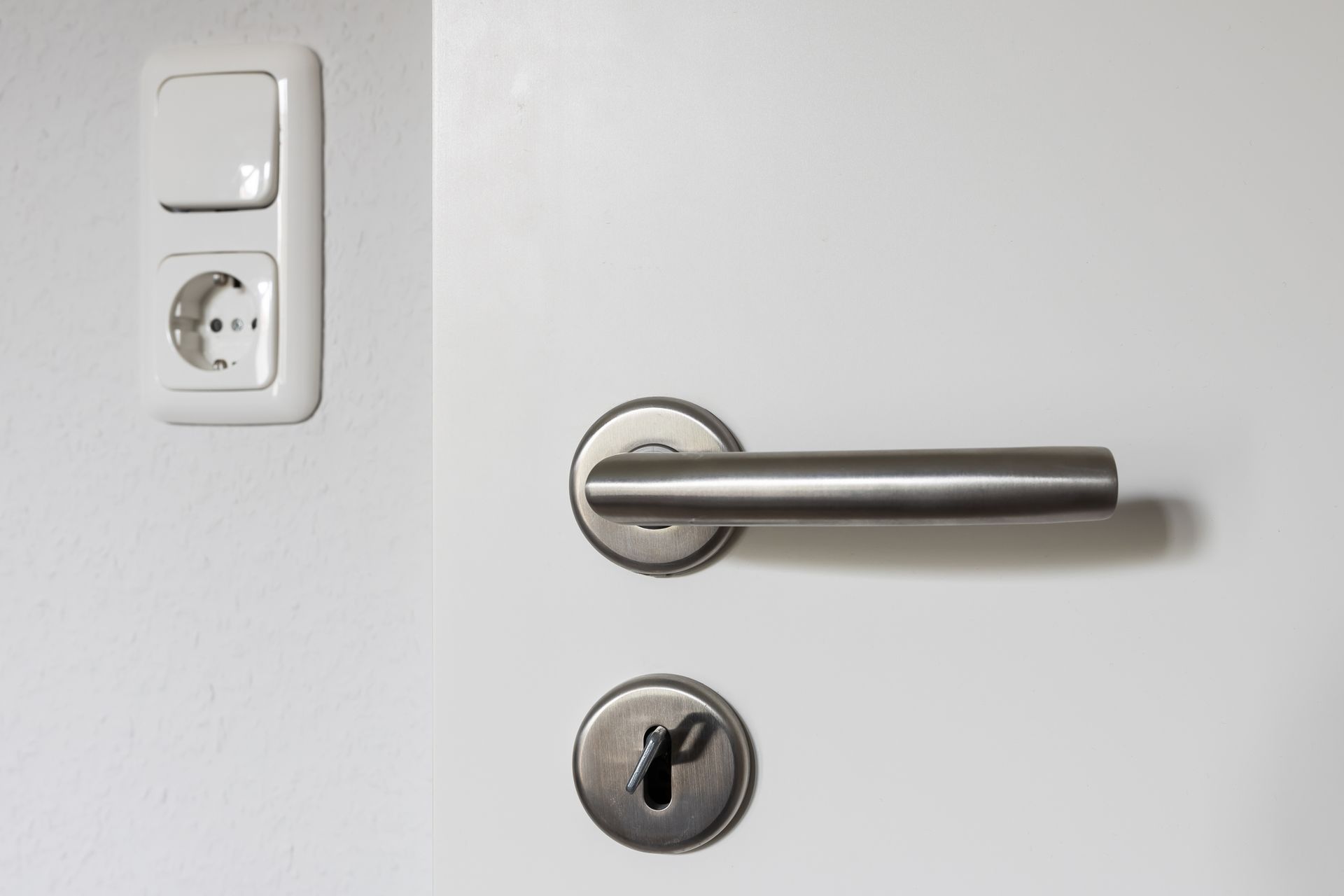 A close up of a door handle and a light switch