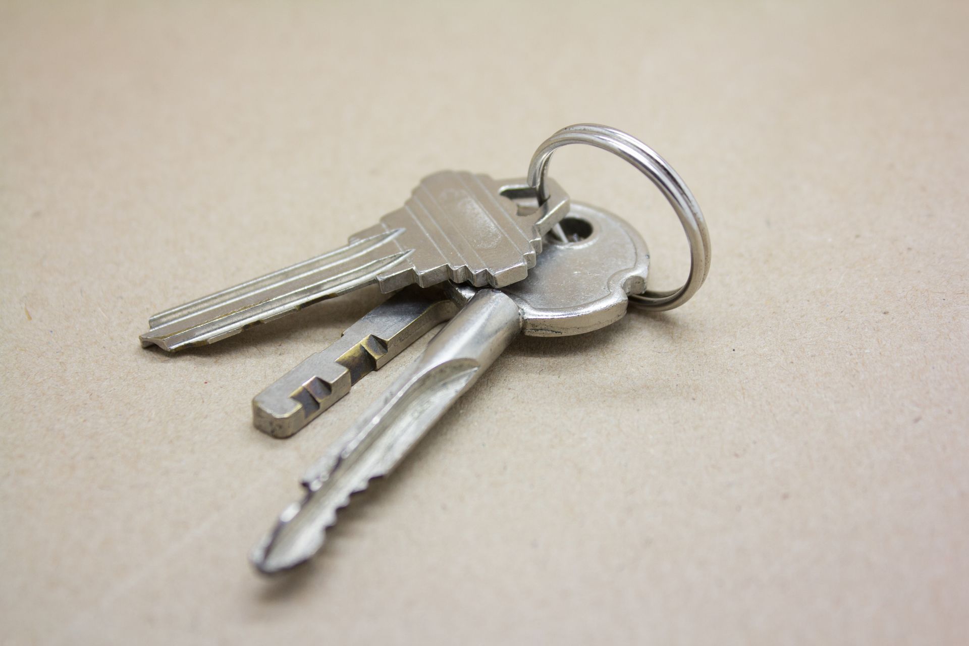 A bunch of keys on a keychain on a table A bunch of keys on a keychain on a table
