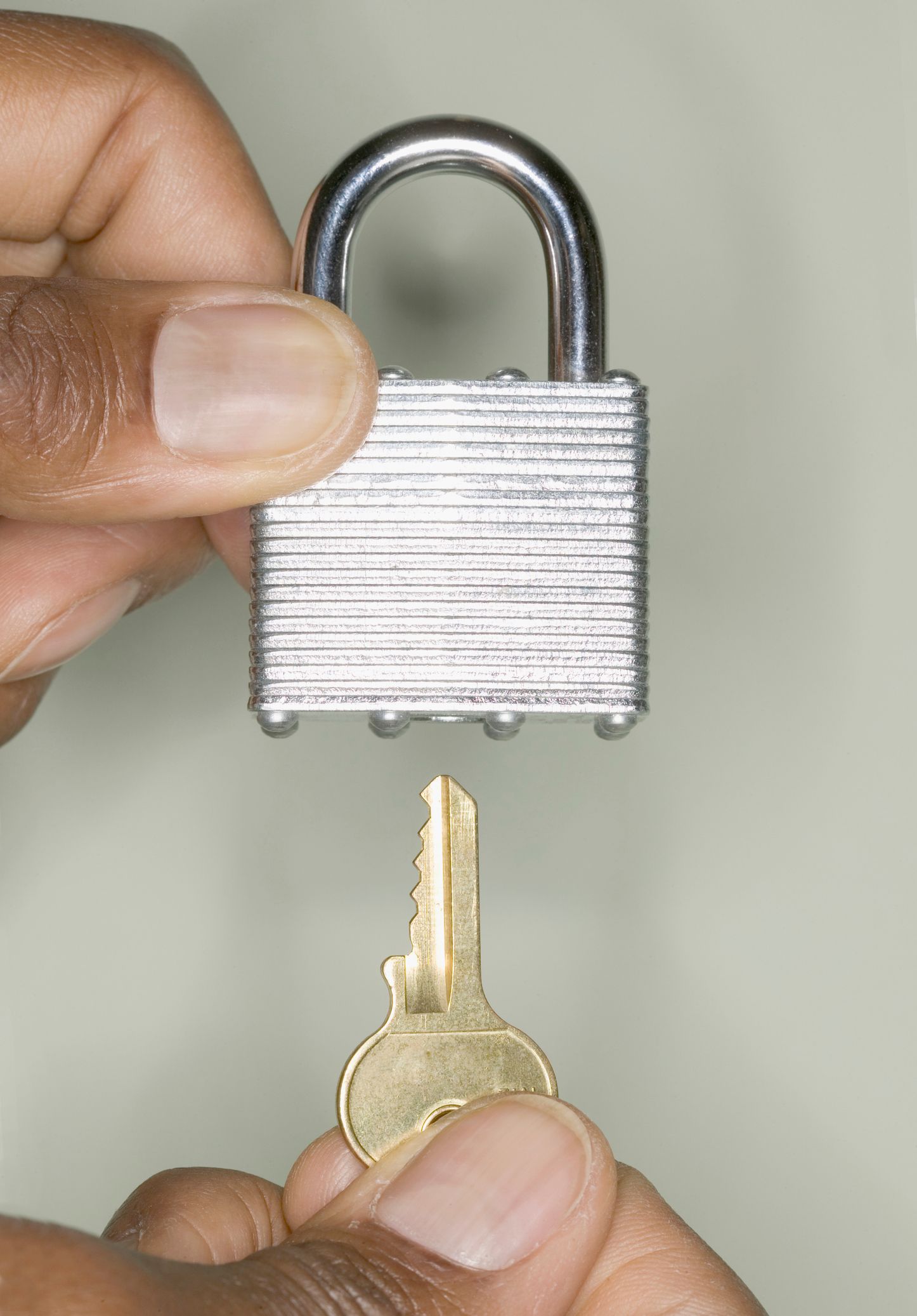 A person is holding a padlock with a key sticking out of it.