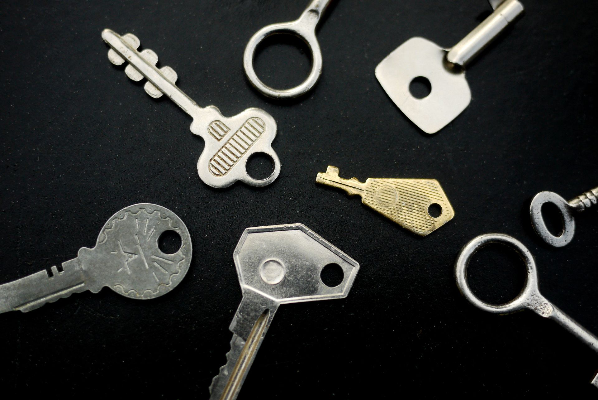 A bunch of keys are laying on a black surface