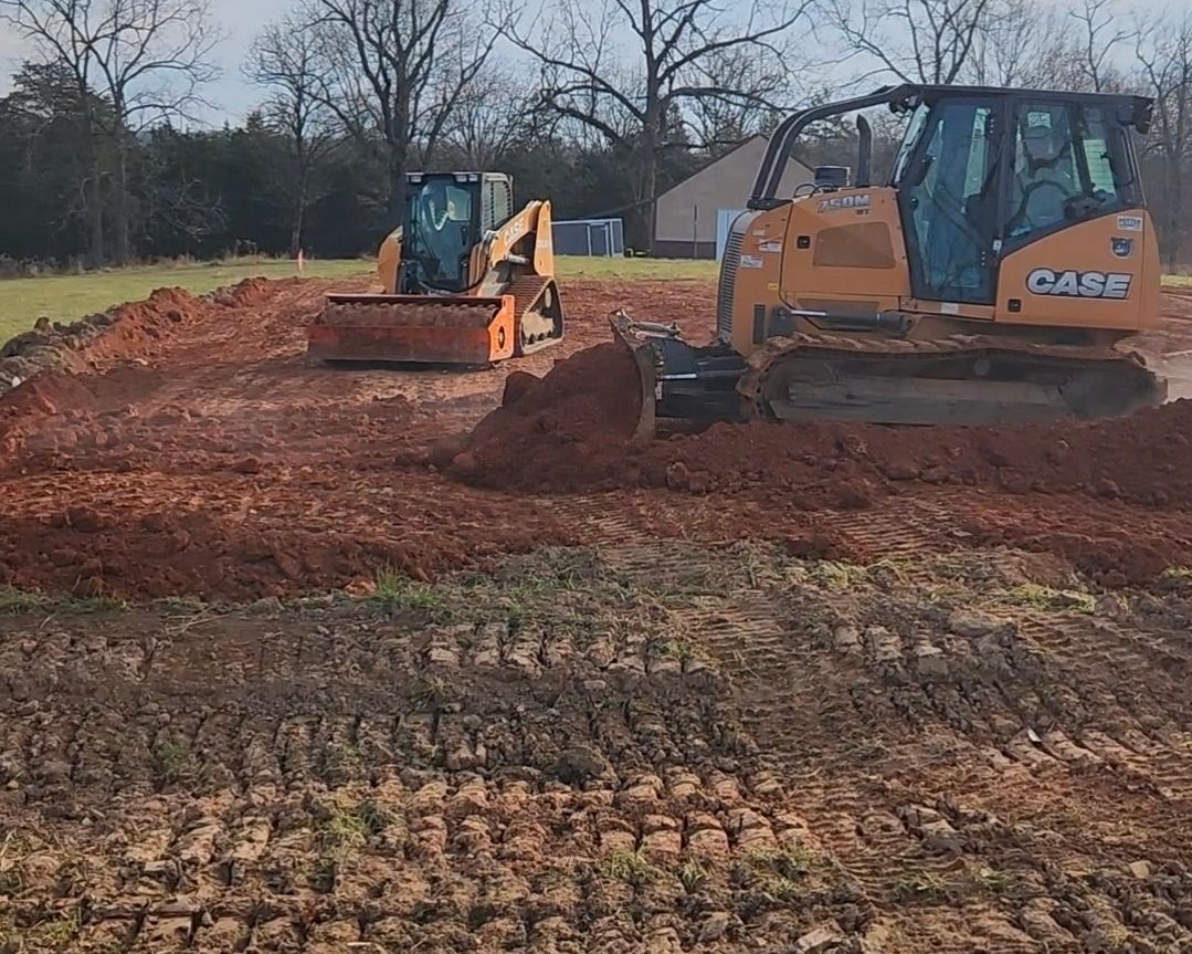 Yellow dozer leveling ground. Rough Cuts Construction.