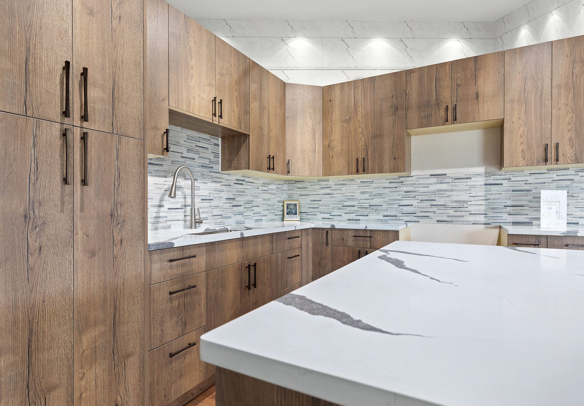 Modern kitchen with wood cabinets, white countertop, and tiled backsplash.