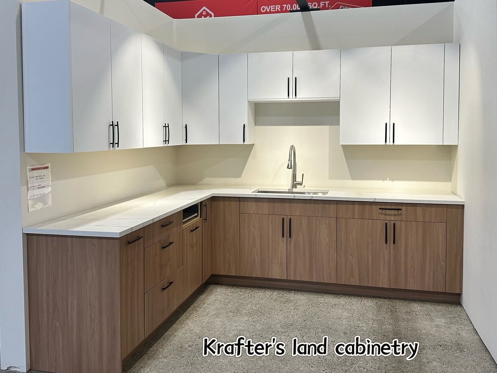 L-shaped kitchen with white upper cabinets, light wood lower cabinets, and a white countertop.