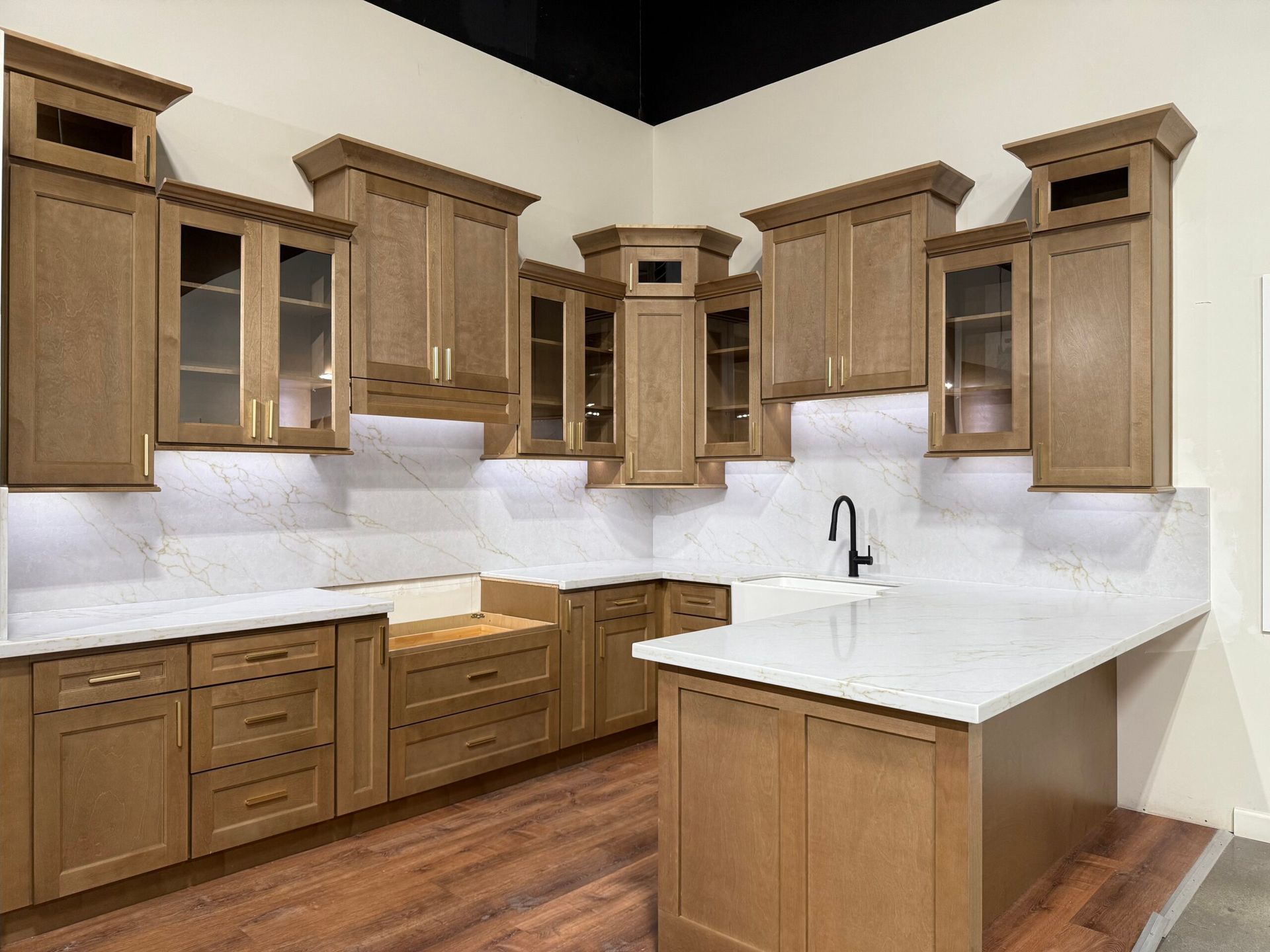 Kitchen with light brown cabinets, white countertops, and hardwood floors.