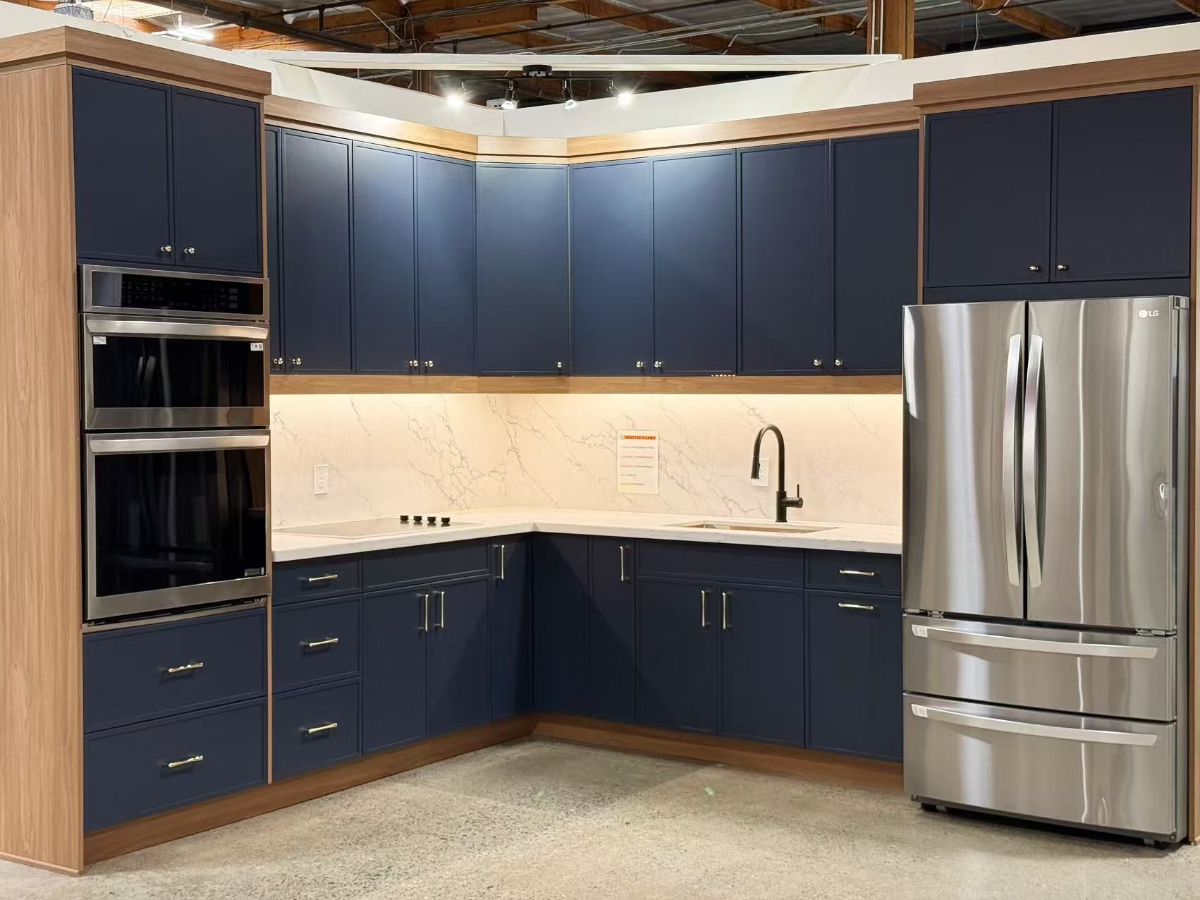Blue and wood kitchen cabinets with stainless steel appliances.