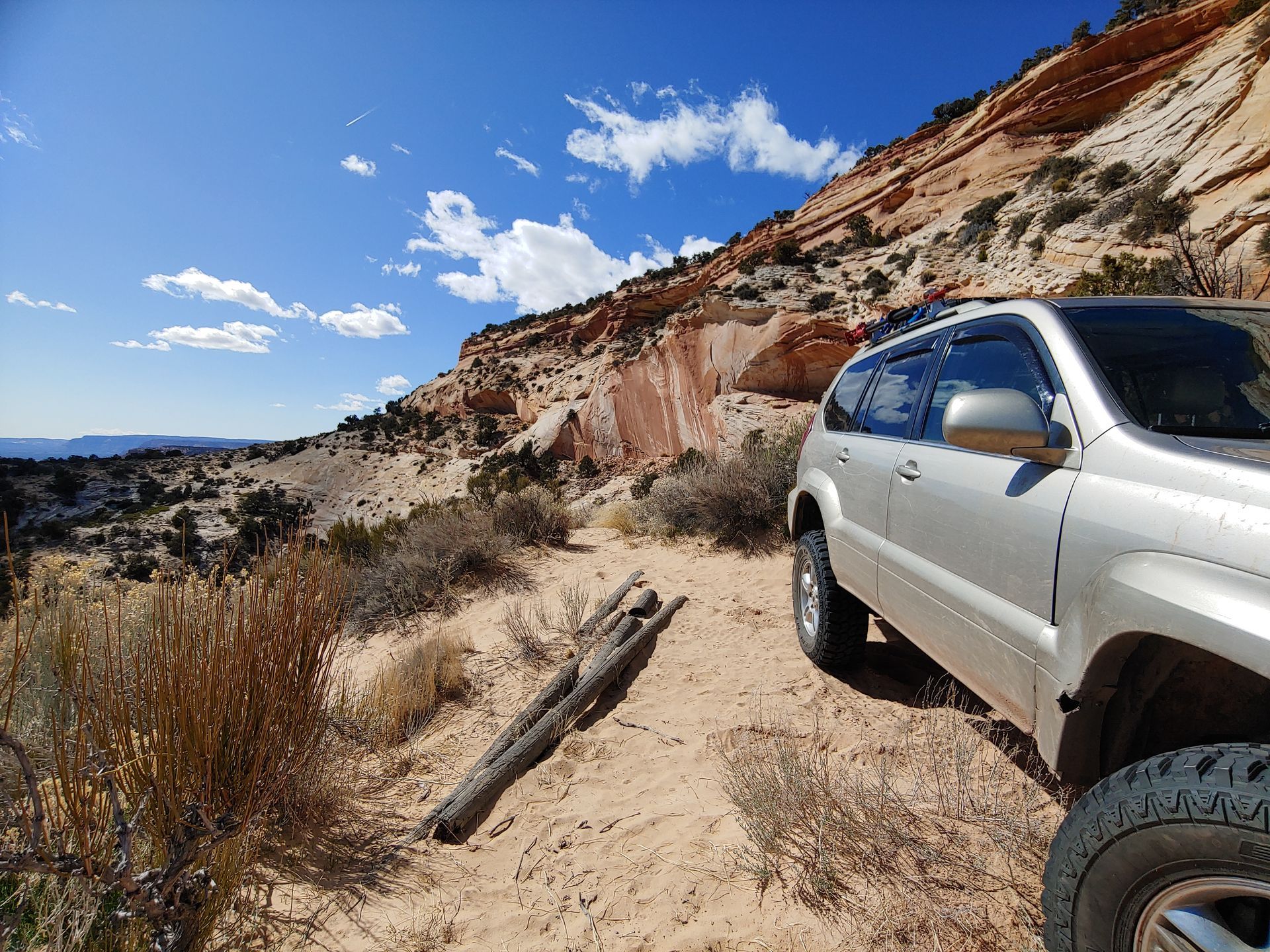 A 4wd vehicle with red and white cliffs in the background