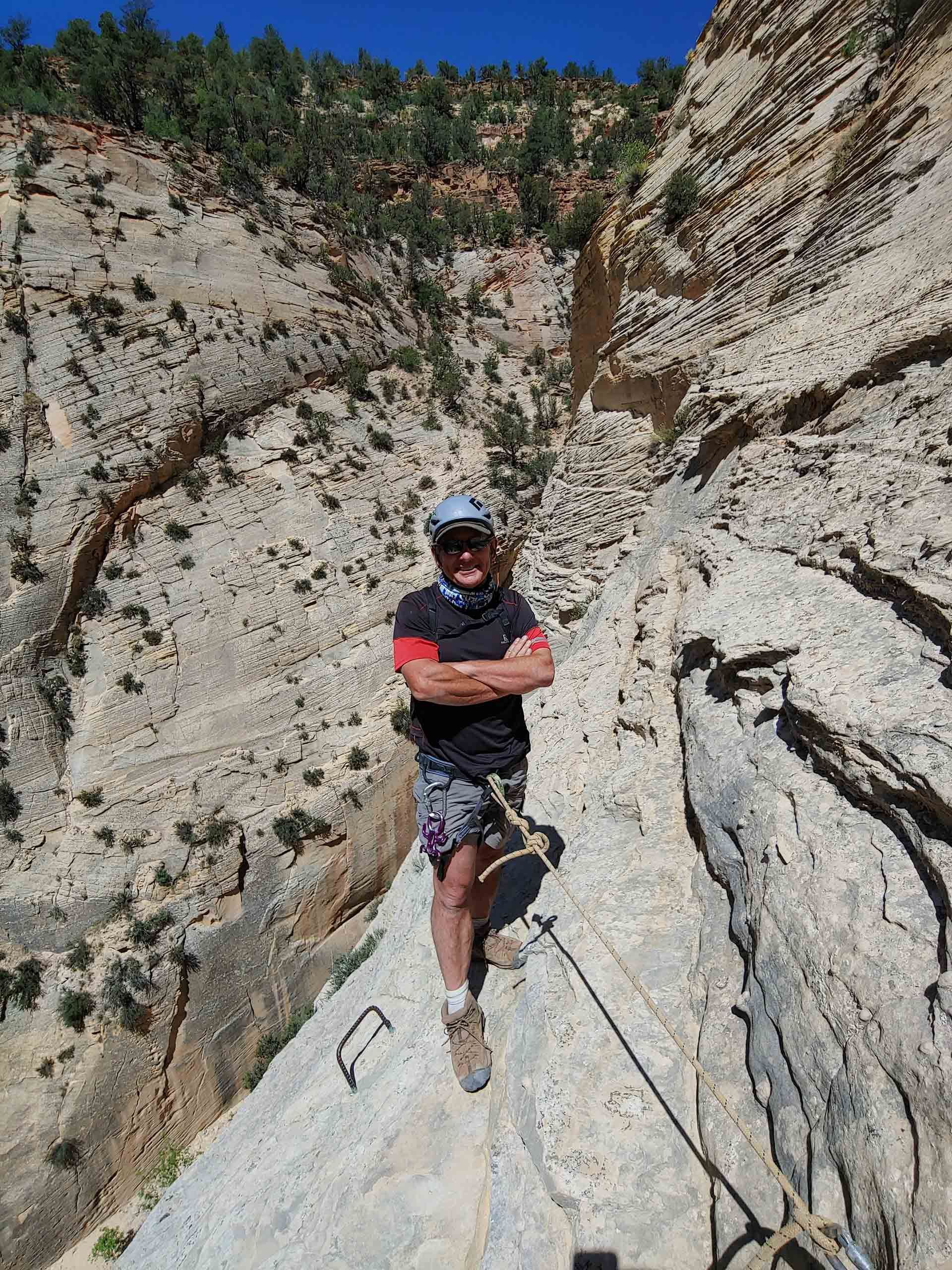 A man is standing on a rock with his arms crossed