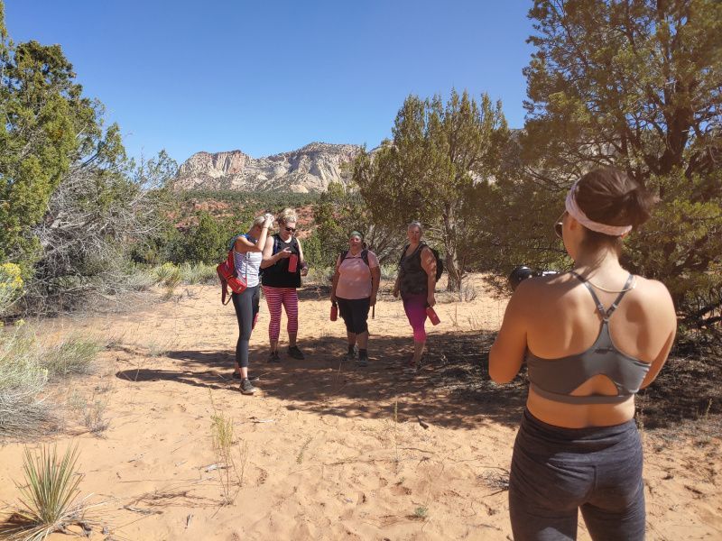 A woman taking a picture of a group of people in the desert
