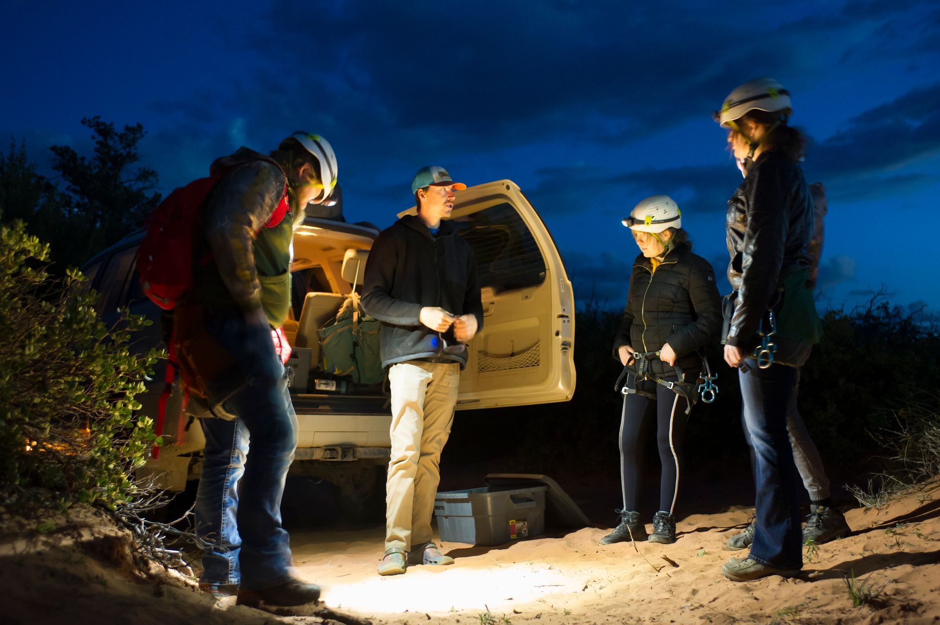 A group of people are standing in front of a vehicle that says ' trail ' on the back