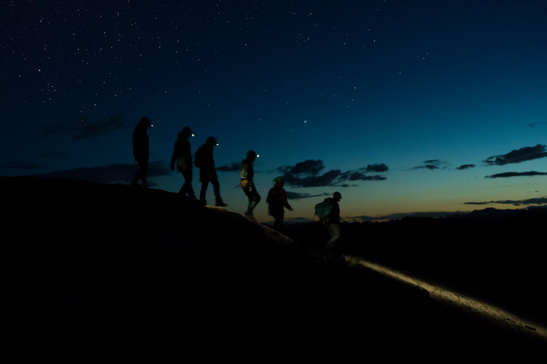 A group of people walking down a hill at night