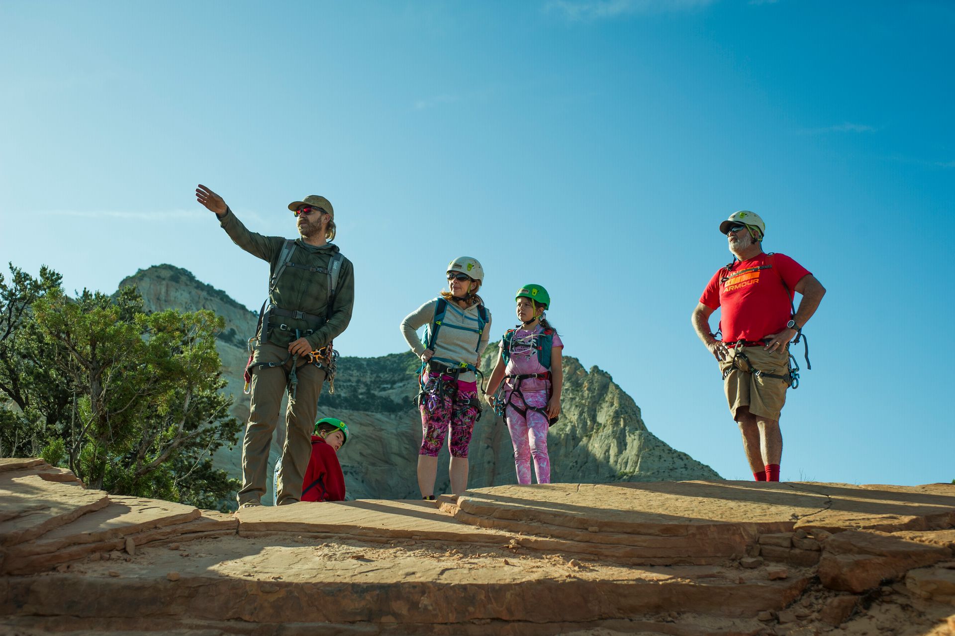 A group of people are standing on top of a rocky hill.
