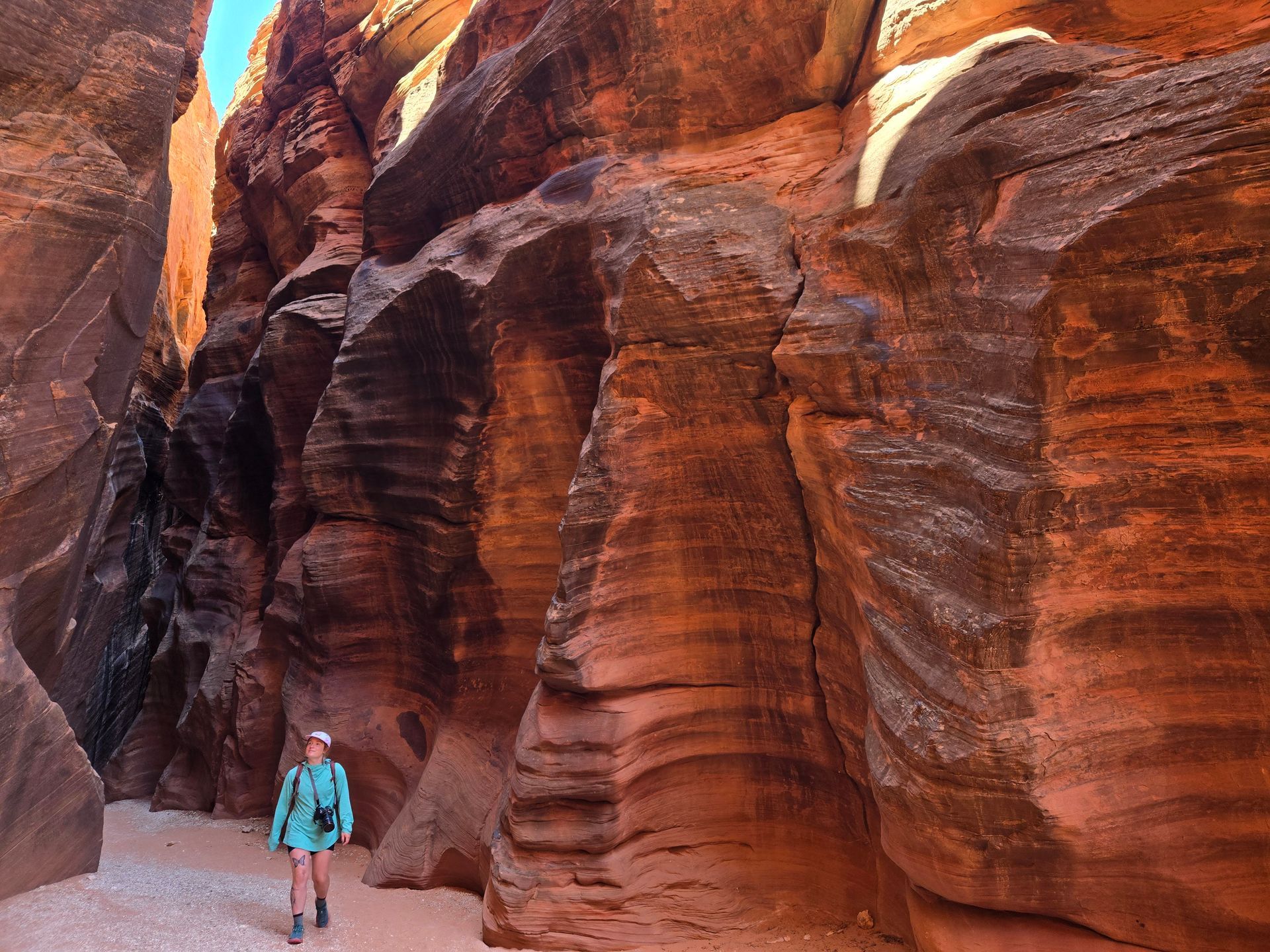 A woman is standing in the middle of a canyon.