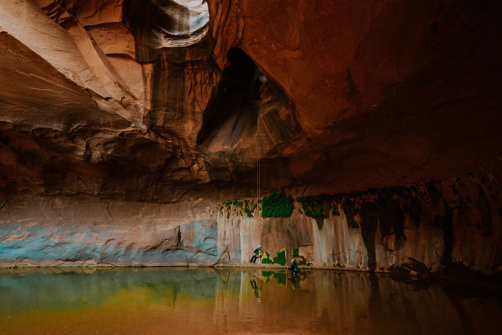 A cave with a reflection of a person in the water